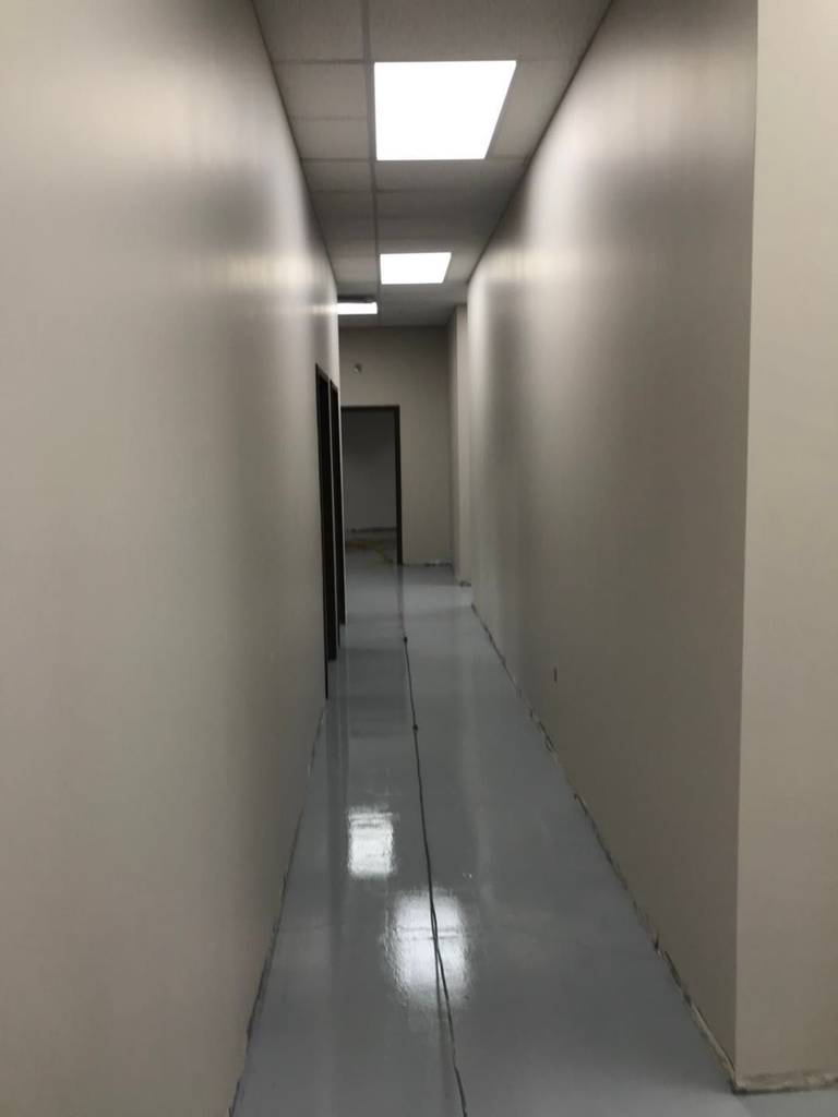 This Toronto commercial renovation highlights a clean and functional office corridor transformation featuring newly installed storage cabinets and seamless grey epoxy flooring. The durable floor coating enhances safety, longevity, and easy maintenance, making it ideal for high-traffic commercial environments. The refreshed layout improves workflow efficiency while maintaining a modern, professional appearance suitable for offices, clinics, warehouses, or retail back-of-house operations in the GTA.