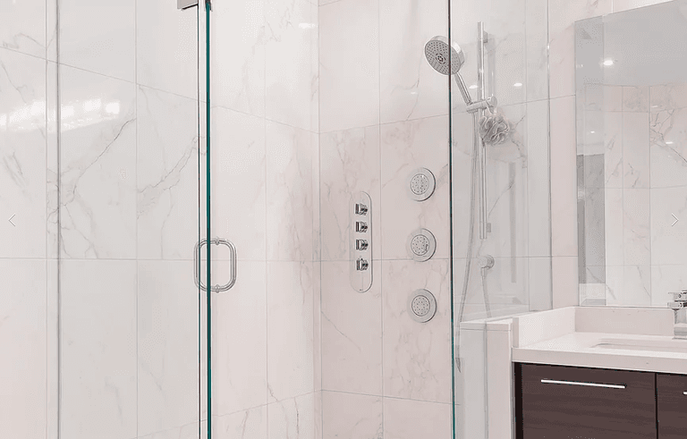 A spa‑inspired bathroom from our Vaughan full house interior renovation featuring a frameless glass shower, marble‑look wall tiles, rainfall showerhead, and a sleek vanity. This elegant upgrade combines modern design with premium finishing details for a calm and refreshing space.