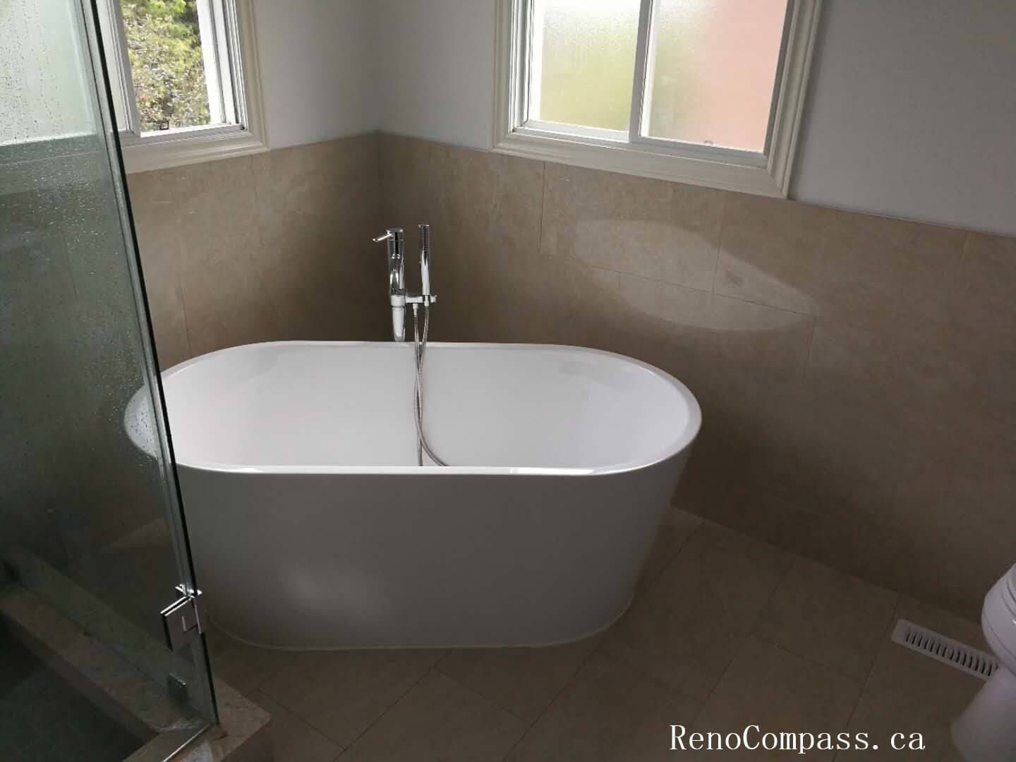 Elegant basement bathroom renovation in Richmond Hill featuring a modern freestanding bathtub, large-format wall tiles, and upgraded fixtures. This basement upgrade combines functionality and contemporary design, creating a comfortable spa-like bathing space with improved lighting, ventilation, and waterproof finishing.