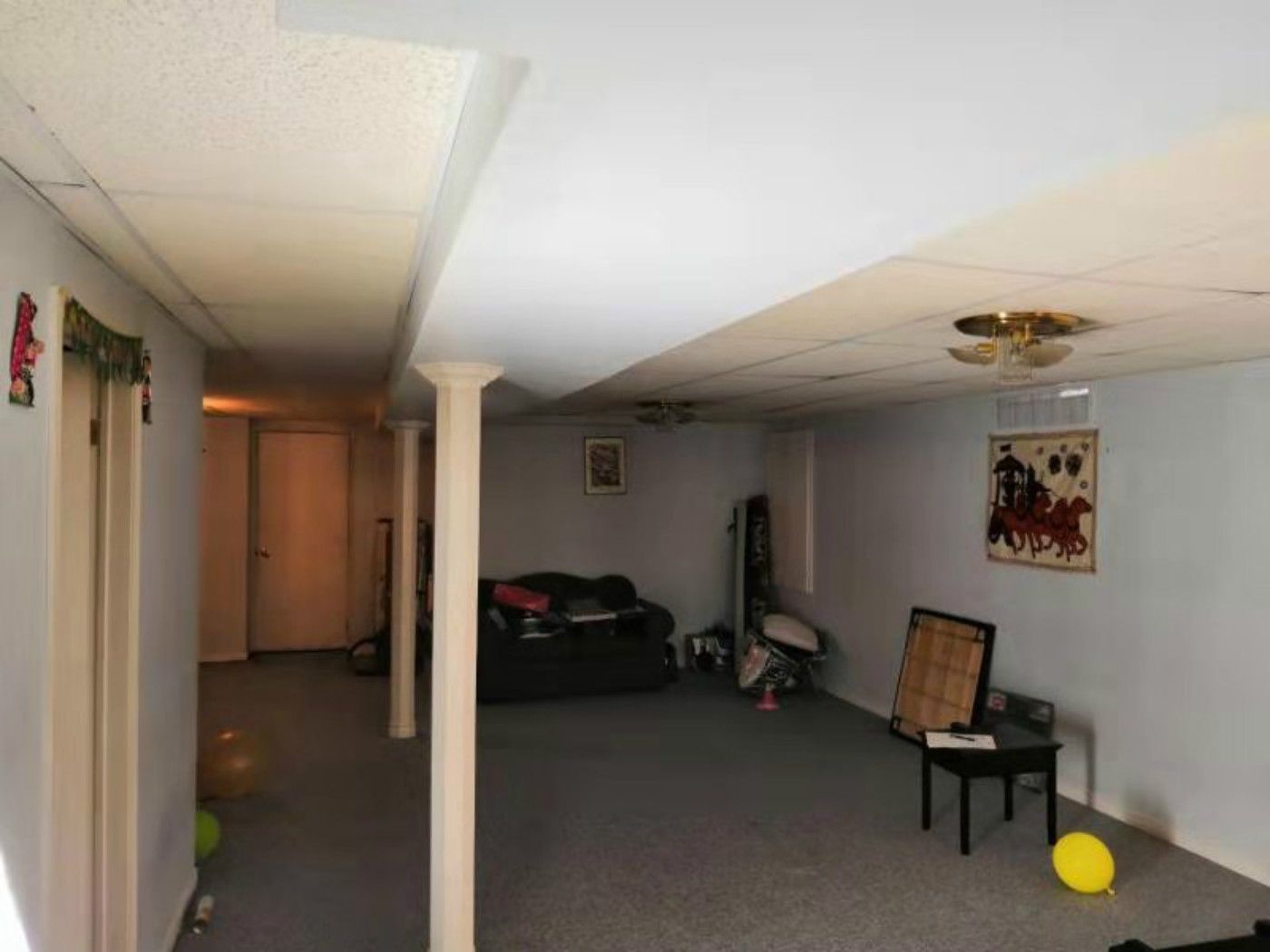 This Mississauga basement features a large open area with structural columns, carpet flooring, and a staircase access point. The space includes basic lighting and a home gym setup, highlighting its potential for a full renovation. A professional Toronto renovation company can transform this basement into a modern, multi-functional living space with improved layout, lighting, and finishes.