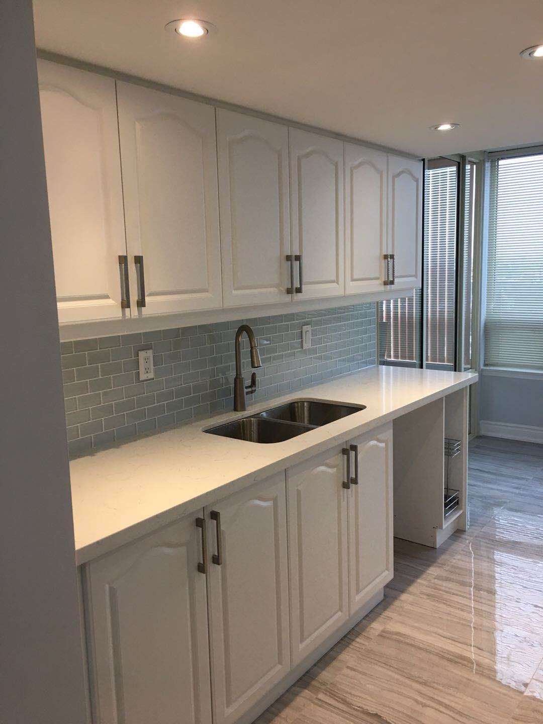 This Toronto interior renovation project features a bright and modern kitchen upgrade with custom white cabinetry, quartz countertops, and a stylish subway tile backsplash. The space was designed to maximize storage, improve lighting, and create a clean contemporary look suitable for everyday living in a Toronto condo.