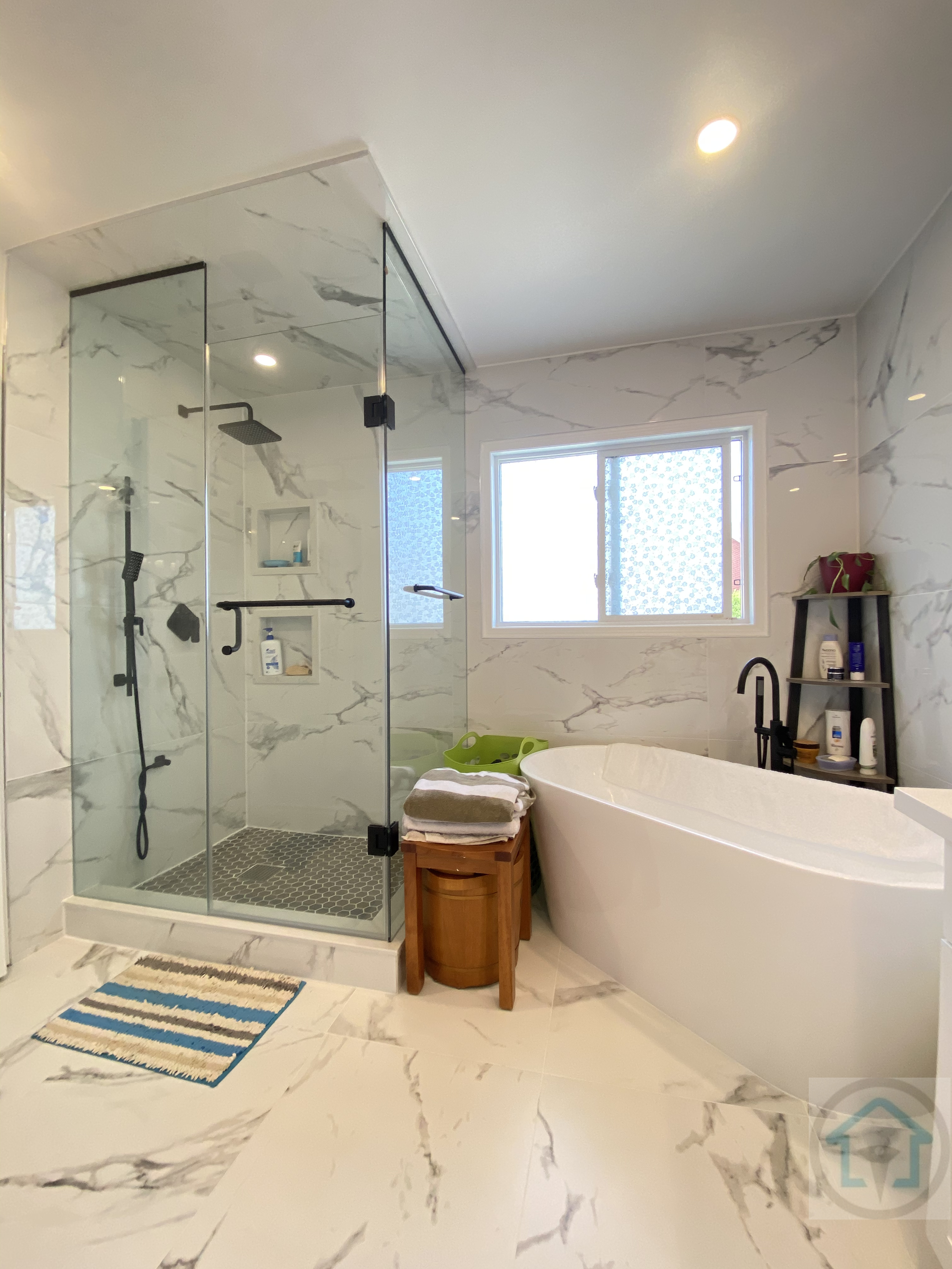 This Richmond Hill bathroom renovation features a spacious walk-in glass shower, a modern freestanding bathtub, and full-height marble-look porcelain tile. The layout was redesigned to improve daily functionality while creating a clean, spa-inspired atmosphere with natural light, matte black fixtures, and durable finishes. Designed and built by Reno Compass Inc., this bathroom renovation reflects a balance of comfort, elegance, and long-term usability for Richmond Hill homeowners.