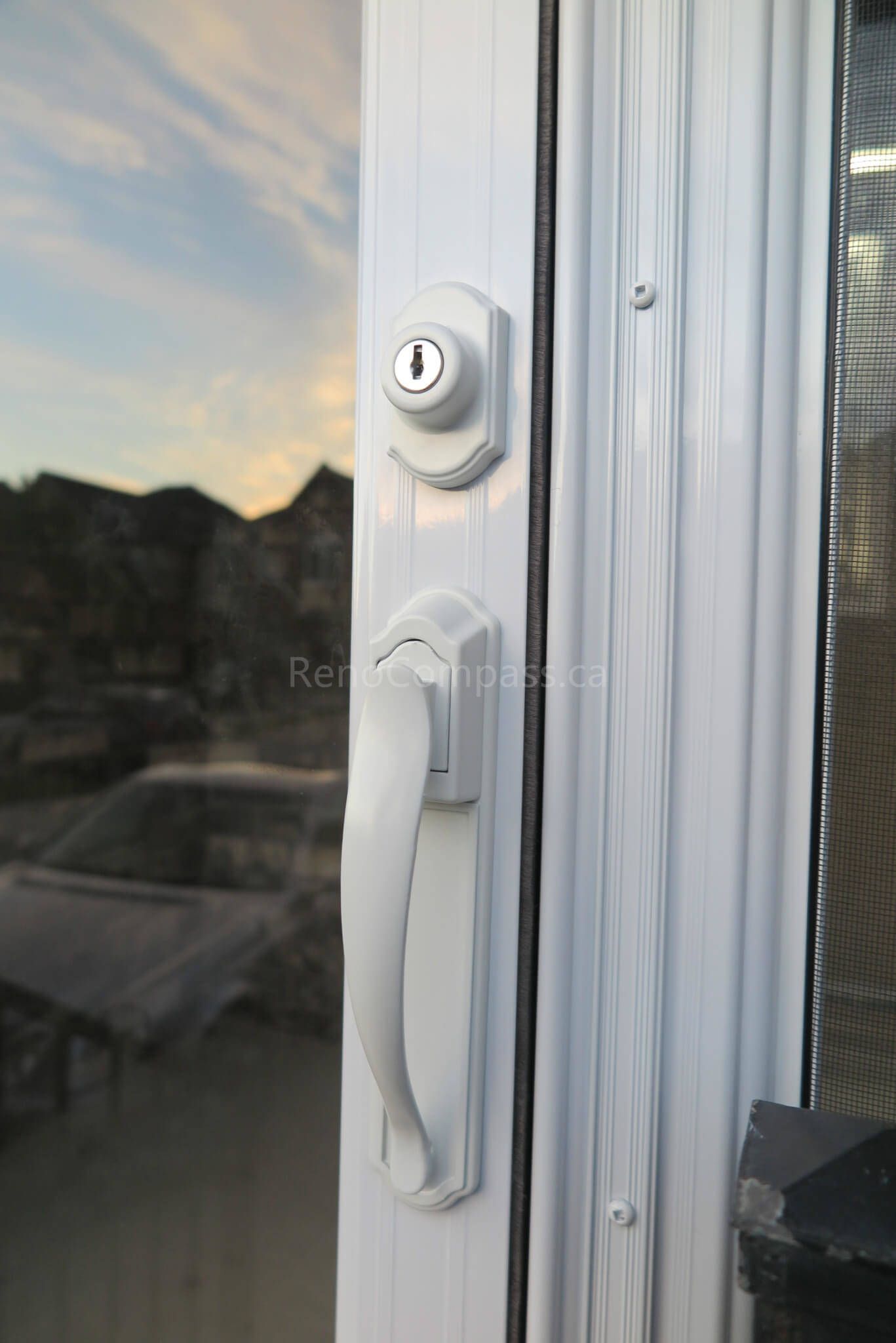Close-up detail of the door handle and lock system from a Markham storm door installation completed by  Reno Compass Inc. The elegant white finish and premium hardware ensure smooth operation, strong security, and a clean modern look for the home exterior.