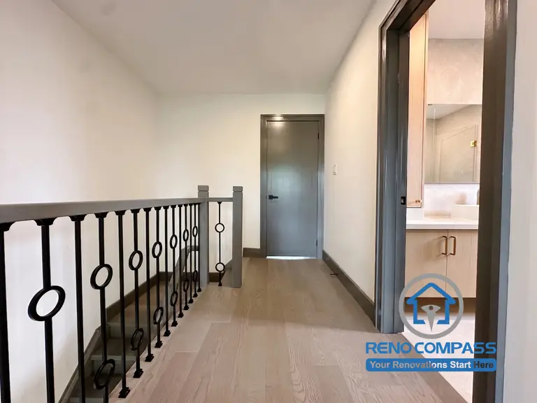 This renovated second-floor hallway features engineered hardwood flooring, custom metal railings, and a clean contemporary design that improves circulation throughout the home. The minimalist finishes and thoughtful detailing create a seamless transition between the bedrooms and bathrooms, contributing to the home's modern aesthetic. Project completed by Reno Compass, serving Markham, Toronto, Richmond Hill, Vaughan, and the Greater Toronto Area.