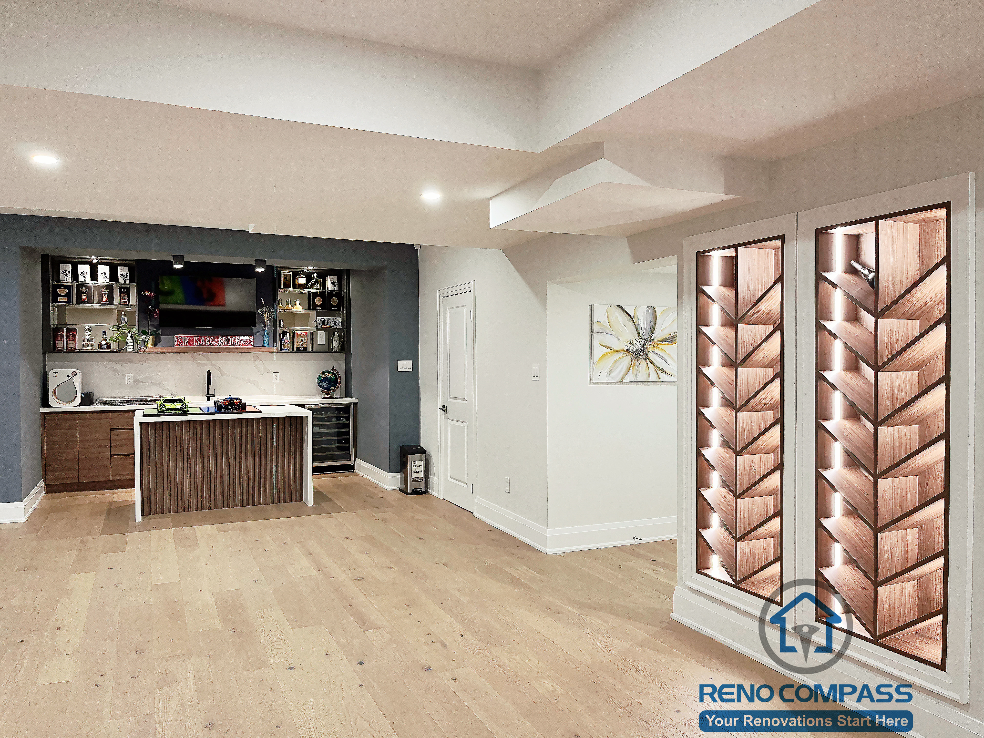 Basement renovation in Newmarket featuring a custom bar area, wood flooring, built-in cabinetry, and modern lighting, creating a functional entertainment space for gatherings and daily use.