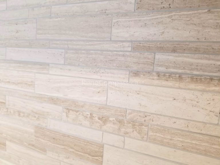 This Mississauga interior renovation features a modern textured wall tile installation that adds depth, warmth, and contemporary character to the space. The natural-toned horizontal tiles create a stylish accent wall that enhances visual interest while maintaining a clean and elegant design.

Completed by Reno Compass Inc., this professional tile installation showcases quality craftsmanship and refined finishing details, elevating the overall interior aesthetic and property value.