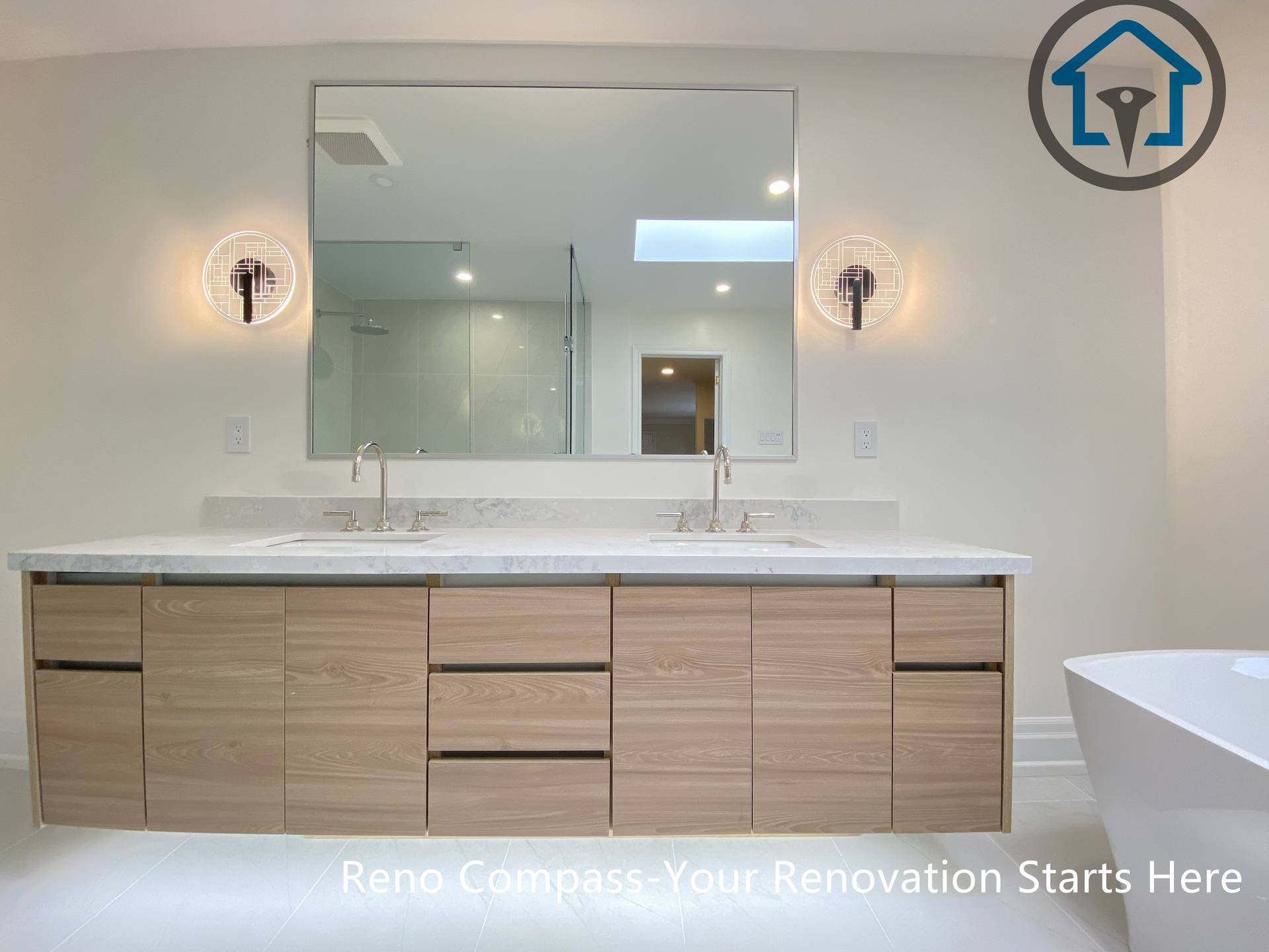 This bathroom renovation features a custom double vanity with integrated lighting, paired with a freestanding bathtub to create a bright and balanced layout. Designed for both functionality and visual clarity in a Thornhill home by Reno Compass.
