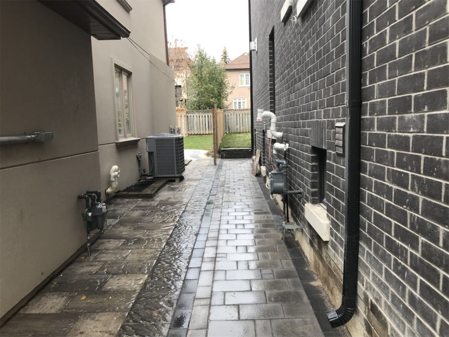 Side yard landscaping project in Toronto featuring a clean interlocking walkway designed for drainage, maintenance access, and improved outdoor functionality. The paved pathway provides durable ground coverage while keeping the side yard organized and accessible.