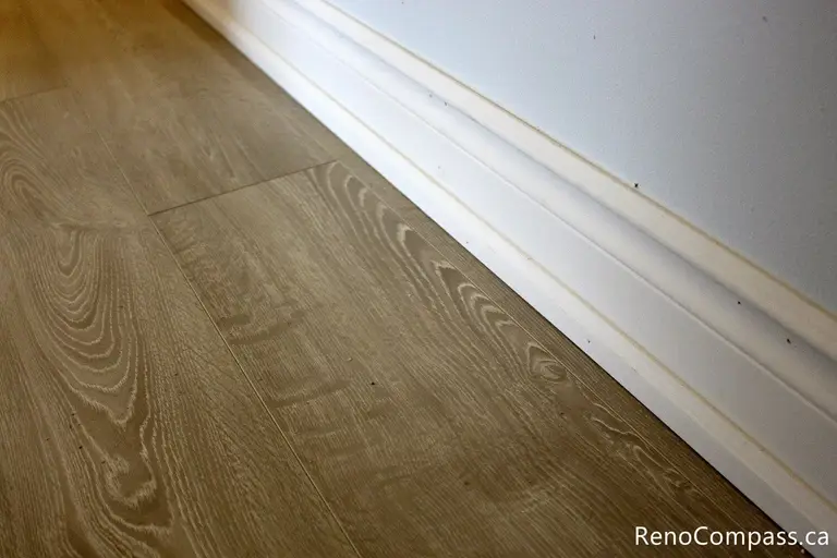 High-quality wide-plank wood-look flooring and custom baseboard installation for an interior renovation in Oshawa, Ontario. Professional craftsmanship by RenoCompass.ca to enhance home value and modern aesthetics.