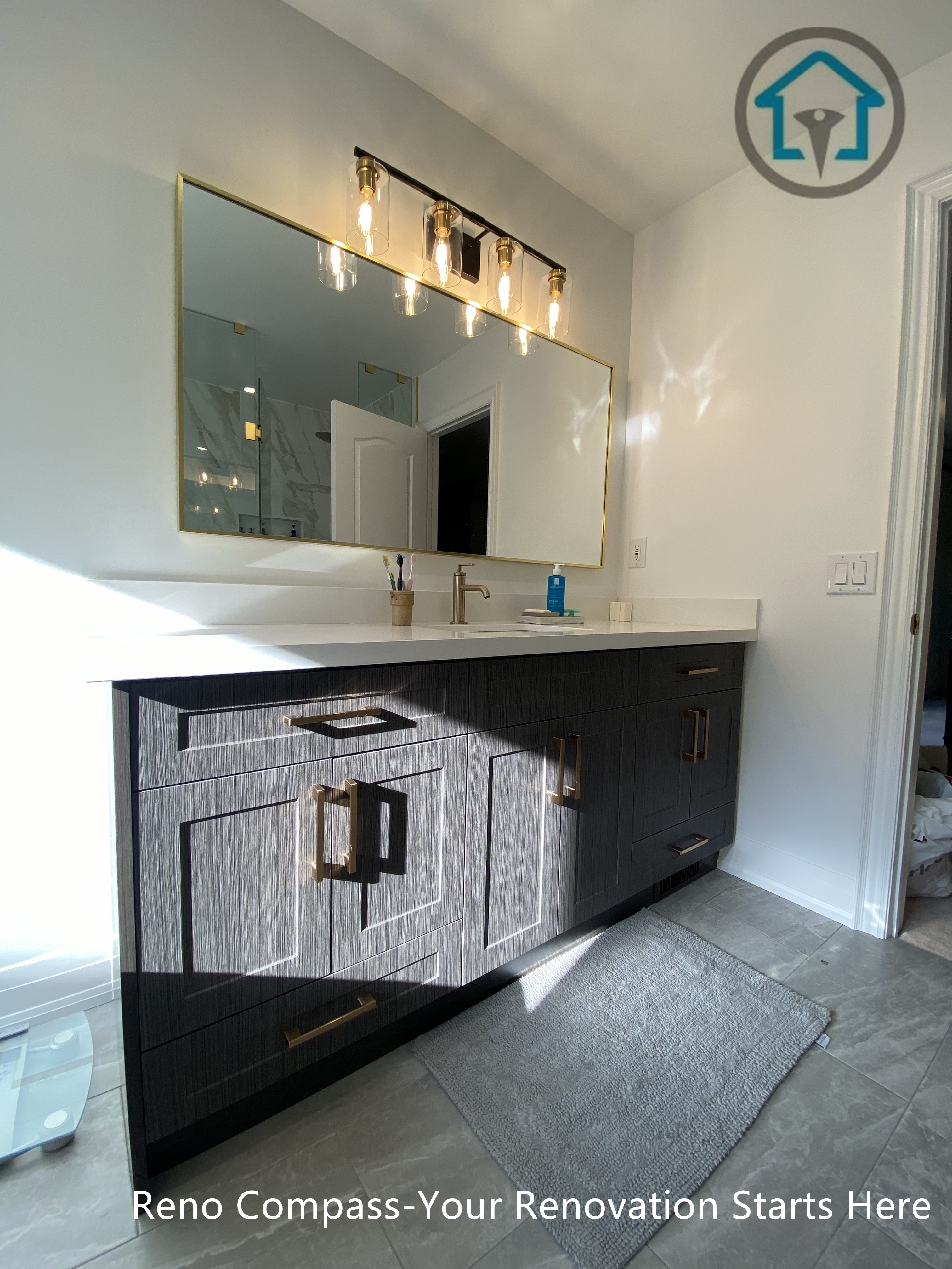 Custom double vanity with textured cabinetry, brass hardware, quartz countertop, and warm lighting in a modern Markham bathroom.