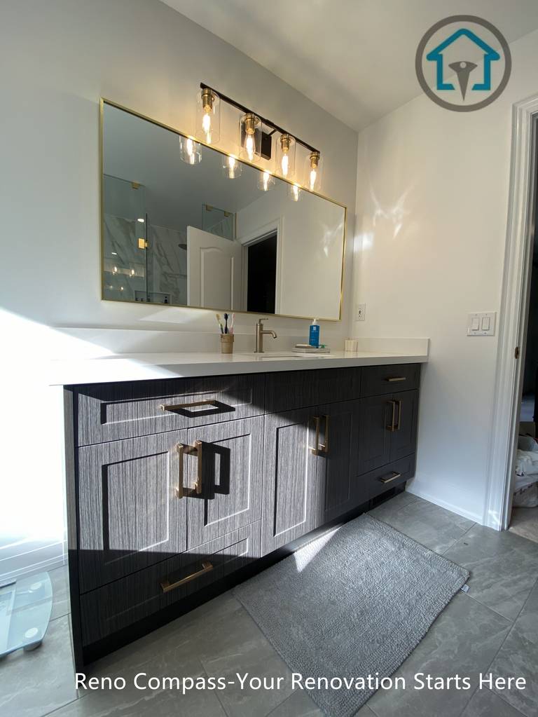 Custom double vanity with textured cabinetry, brass hardware, quartz countertop, and warm lighting in a modern Markham bathroom.