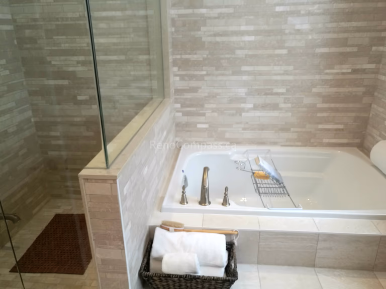 This image showcases a modern bathroom completed as part of a Toronto interior renovation project. The space features a built-in soaking tub paired with a glass-enclosed shower, creating a clean and functional layout. Neutral-toned tile finishes add texture and warmth, while the frameless glass panel enhances openness and visual continuity. Carefully selected fixtures and practical storage details contribute to a calm, spa-like atmosphere. This bathroom renovation highlights quality craftsmanship and thoughtful material selection tailored to contemporary Toronto homes.