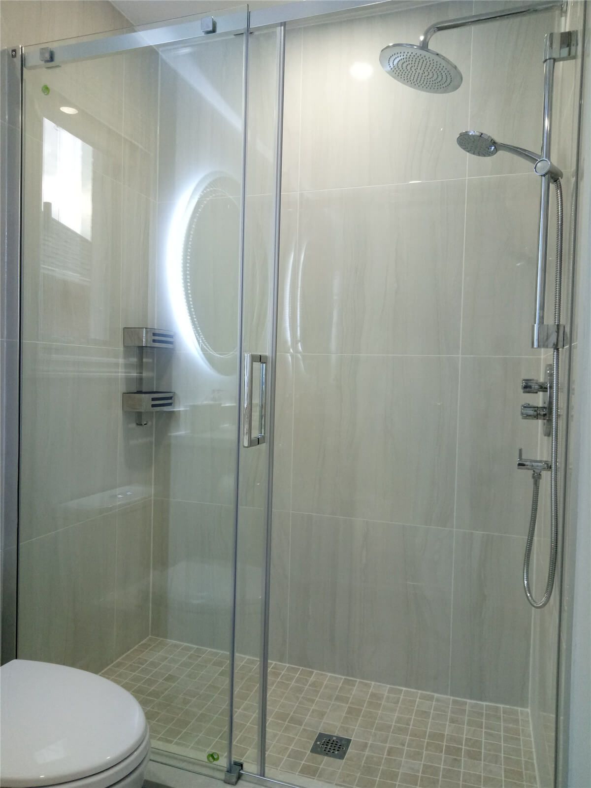 This Richmond Hill bathroom renovation features a sleek frameless glass shower enclosure paired with modern wall and floor tiles for a clean, contemporary look. The upgraded rainfall shower system and handheld fixture enhance comfort and functionality, while the neutral tile palette creates a bright and spacious atmosphere. Designed for durability and everyday convenience, this shower renovation adds both value and modern elegance to the home’s interior.