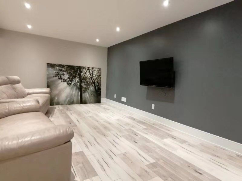 This Richmond Hill interior partial renovation showcases a modern basement living and entertainment space featuring upgraded flooring, recessed lighting, and a contemporary accent wall with mounted TV setup. The redesigned layout creates a comfortable and stylish area for family gatherings, movie nights, and everyday relaxation. Neutral tones and high-quality finishes enhance brightness and visual depth, adding both functionality and value to the home. Completed by Reno Compass, this interior remodeling project highlights professional basement renovation services across Richmond Hill and the Greater Toronto Area.