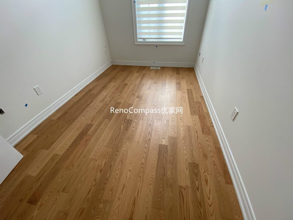 Spacious living area renovation featuring premium wood flooring and smooth neutral paint finish, creating a cozy and clean modern home by Reno Compass in Richmond Hill.