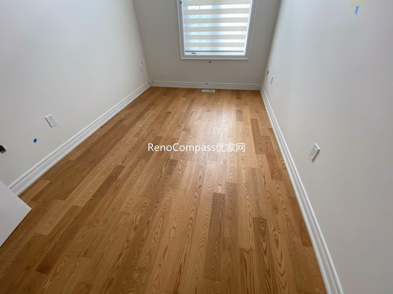 Spacious living area renovation featuring premium wood flooring and smooth neutral paint finish, creating a cozy and clean modern home by Reno Compass in Richmond Hill.