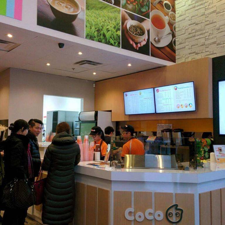 Bubble tea shop commercial renovation in Toronto featuring a bright service counter, decorative wall graphics, digital menu boards, and efficient drink preparation area. This modern retail renovation creates a clean and welcoming bubble tea store environment while optimizing workflow for staff and customer service. A professional Toronto bubble tea shop renovation project completed by a Toronto renovation company.