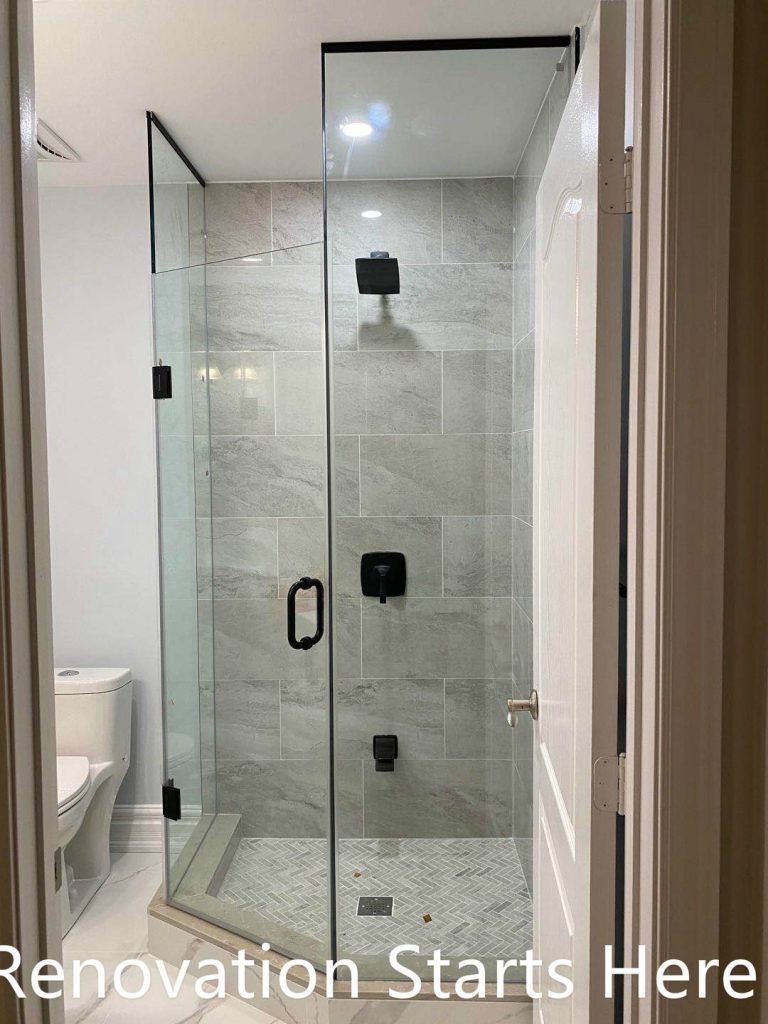 This Thornhill bathroom renovation features a compact walk-in shower enclosed with frameless glass, maximizing visual openness within a narrow layout. Large-format gray wall tiles combined with a herringbone-patterned shower base add texture and depth, while matte black shower fixtures provide a modern, cohesive finish. The clean layout and glass enclosure improve brightness, circulation, and daily functionality, making the space well-suited for guest or secondary bathroom use.