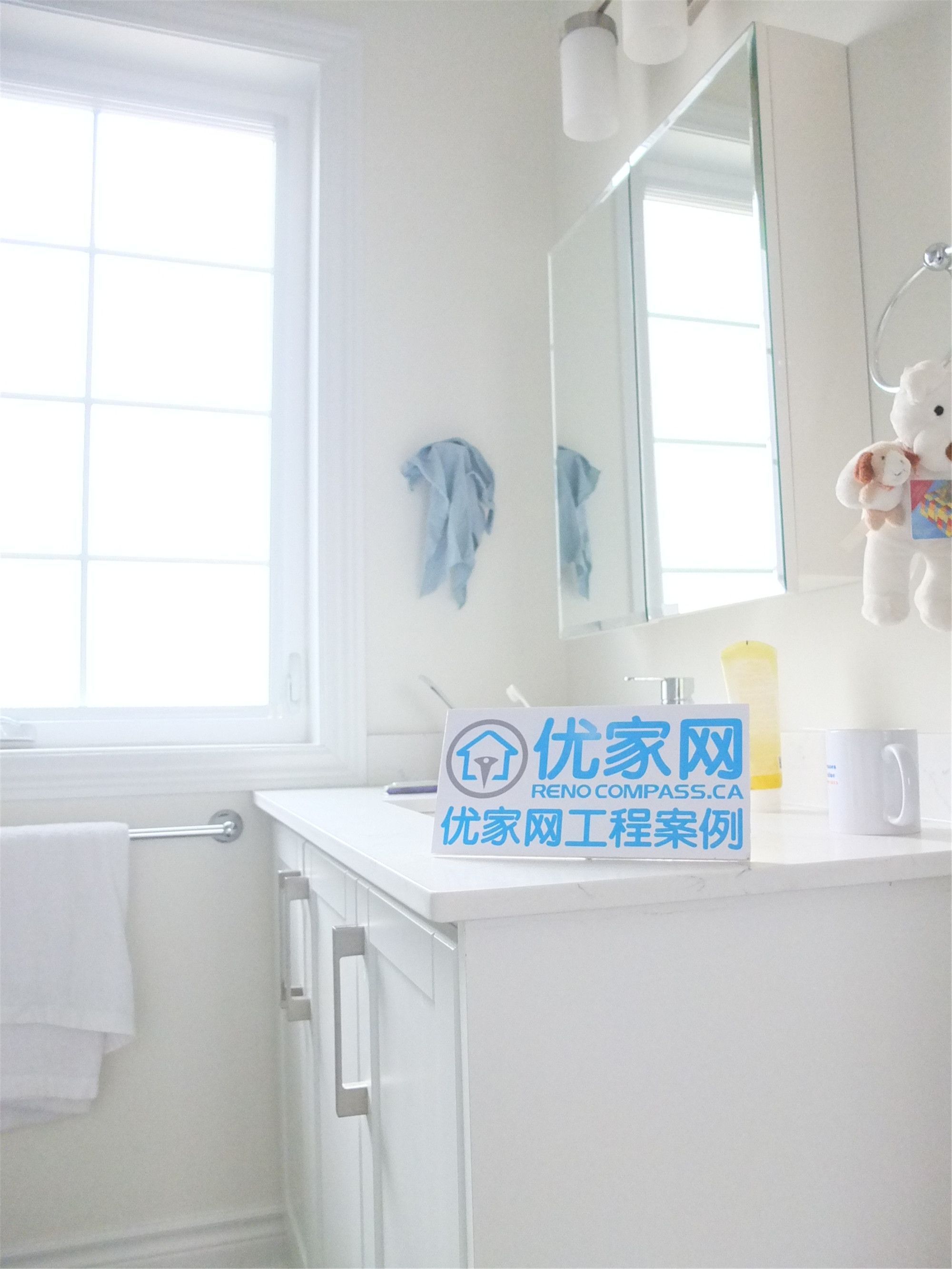Bright bathroom space from a Scarborough home addition project featuring a modern white vanity cabinet, mirror storage, and large window for natural light. The renovation improves functionality and comfort while maintaining a clean and contemporary interior design.