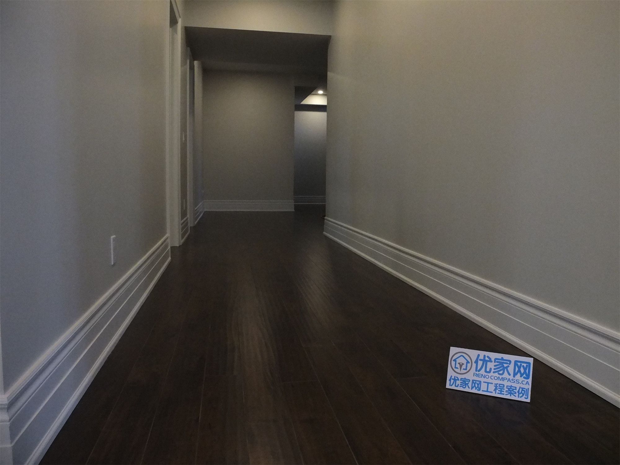 This Richmond Hill basement renovation showcases a clean and modern hallway design featuring recessed pot lights, smooth painted walls, and dark hardwood flooring. The extended corridor layout improves space flow and connects different functional areas within the basement efficiently.