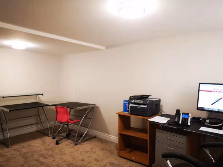 This Mississauga basement features a simple home office corner with carpet flooring, basic desk setup, and limited lighting. The space highlights opportunities for improved layout, storage solutions, and modern finishes. A professional Toronto renovation company can upgrade this area into a more efficient, comfortable, and visually appealing workspace.