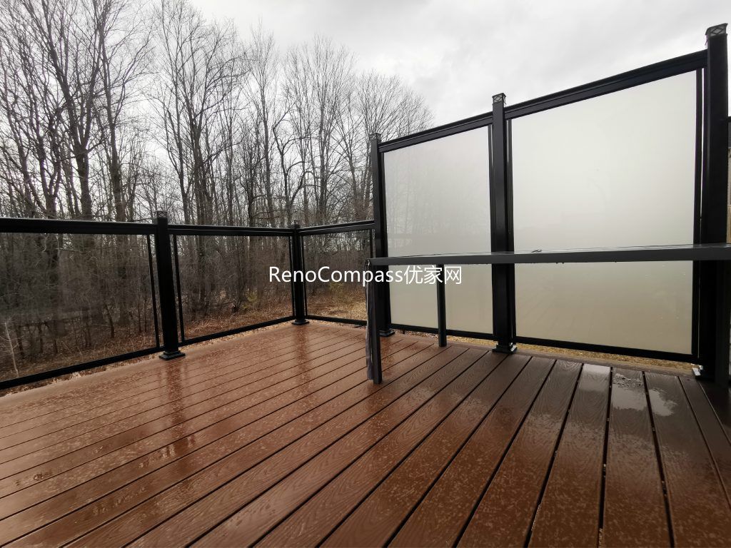 Modern backyard deck renovation project in Aurora featuring durable composite deck flooring, black aluminum and frosted glass privacy railings, and professional interlocking installation. This outdoor renovation enhances privacy, safety, and visual appeal while creating a functional and stylish outdoor living space for homeowners.