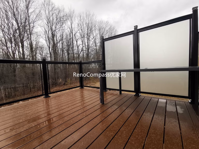 Modern backyard deck renovation project in Aurora featuring durable composite deck flooring, black aluminum and frosted glass privacy railings, and professional interlocking installation. This outdoor renovation enhances privacy, safety, and visual appeal while creating a functional and stylish outdoor living space for homeowners.