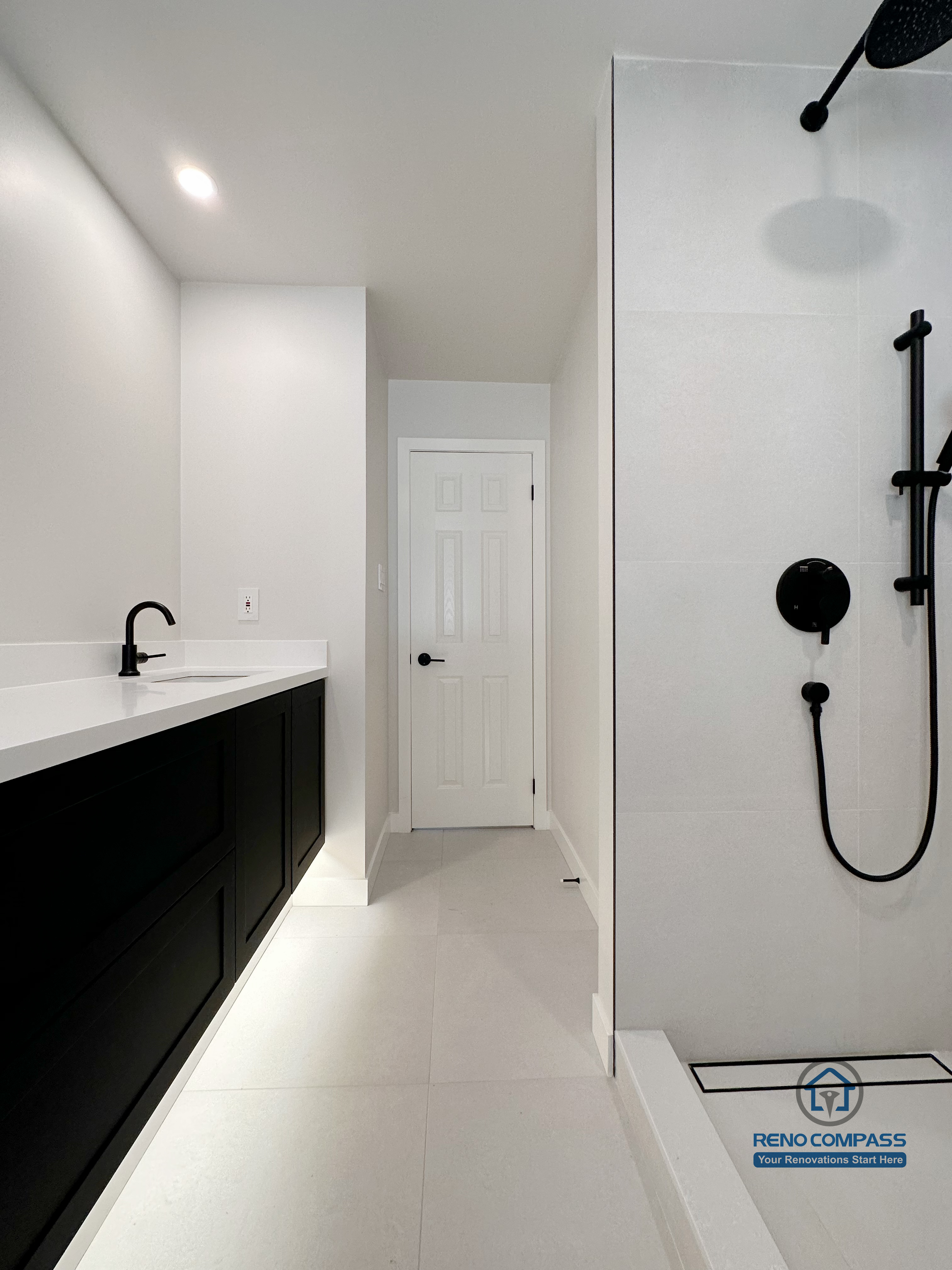 Modern bathroom renovation in Markham featuring a glass walk-in shower, matte black fixtures, and a sleek vanity with ample storage. The linear layout, bright finishes, and minimalist detailing create a clean, functional bathroom designed for everyday comfort and easy maintenance.