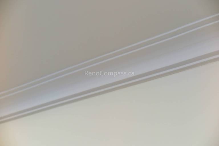This North York renovation project features clean and elegant crown moulding installation that enhances the ceiling and wall transition with a refined finish. The crisp white trim adds depth and architectural detail while complementing the modern interior design. Completed by Reno Compass Inc., this interior finishing upgrade delivers a polished, high-end look that elevates the overall home renovation quality.