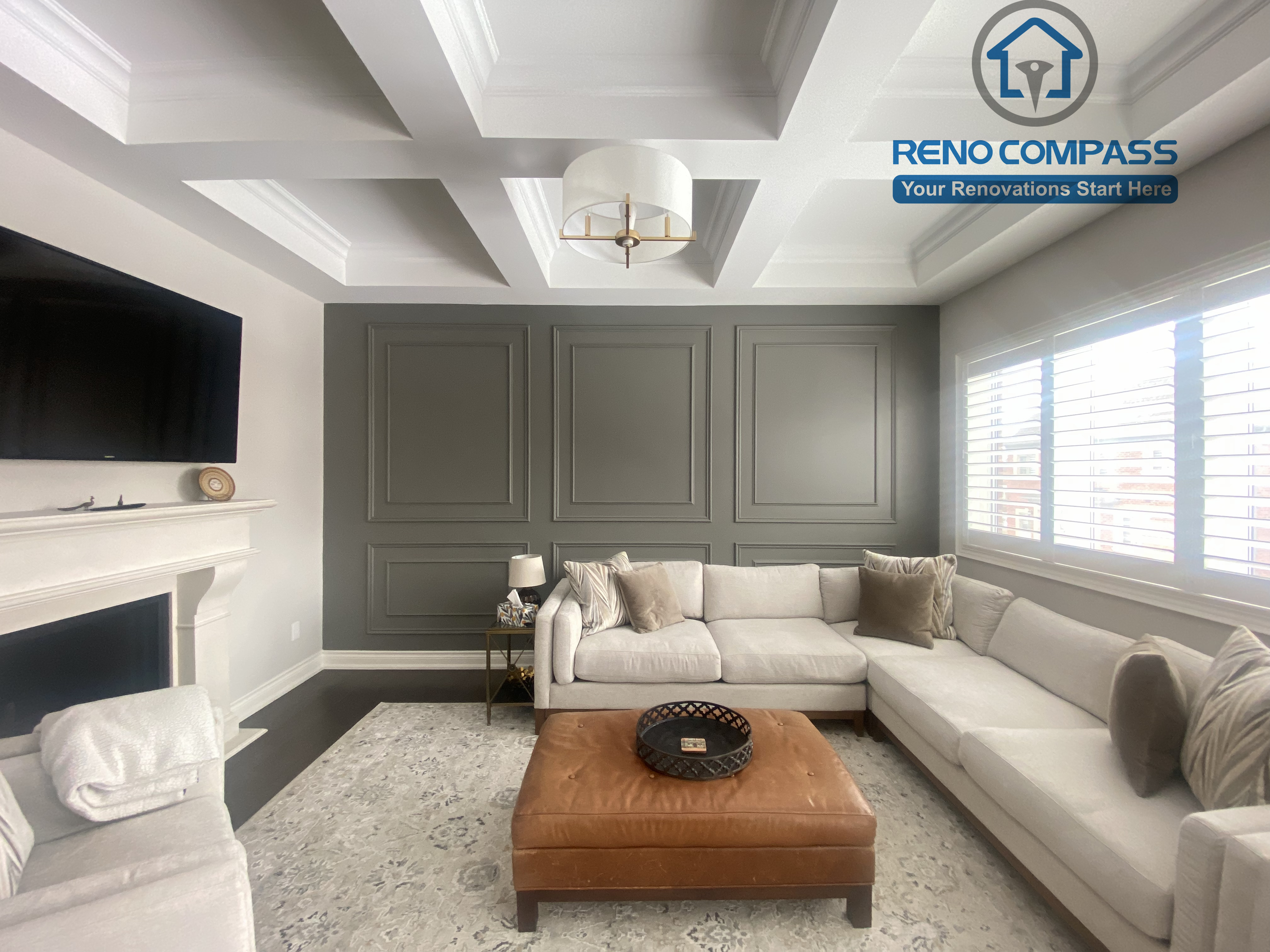 This Vaughan interior renovation features an elegant living room with a coffered ceiling, custom wall paneling, fireplace detail, and refined lighting. Neutral tones and balanced proportions create a sophisticated and comfortable space, completed by a professional Toronto renovation company.