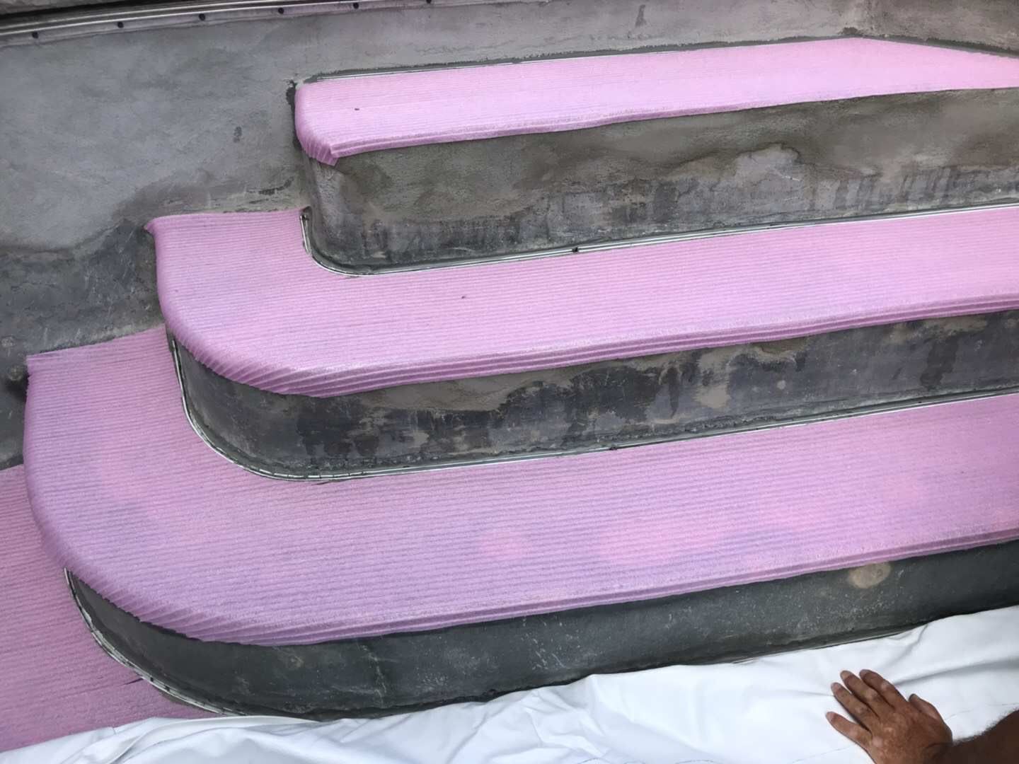 Swimming pool renovation in Toronto featuring step resurfacing and protective underlayment installation. This stage highlights detailed preparation of pool stairs with cushioning layers and structural repair to ensure a smooth, durable finish before final pool liner or surface installation by a professional Toronto contractor.