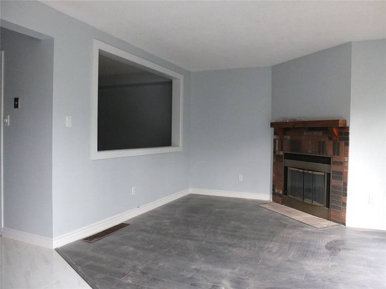 This Mississauga interior renovation showcases a refreshed living space with new flooring, smooth wall finishes, and a classic fireplace feature. The neutral grey palette enhances brightness and allows flexible furniture layout options for modern family living. A custom interior wall opening improves visual connection between rooms while maintaining defined spaces. Clean trim work and durable flooring ensure long-term functionality and comfort. Completed by a professional Toronto renovation company specializing in high-quality interior home upgrades.