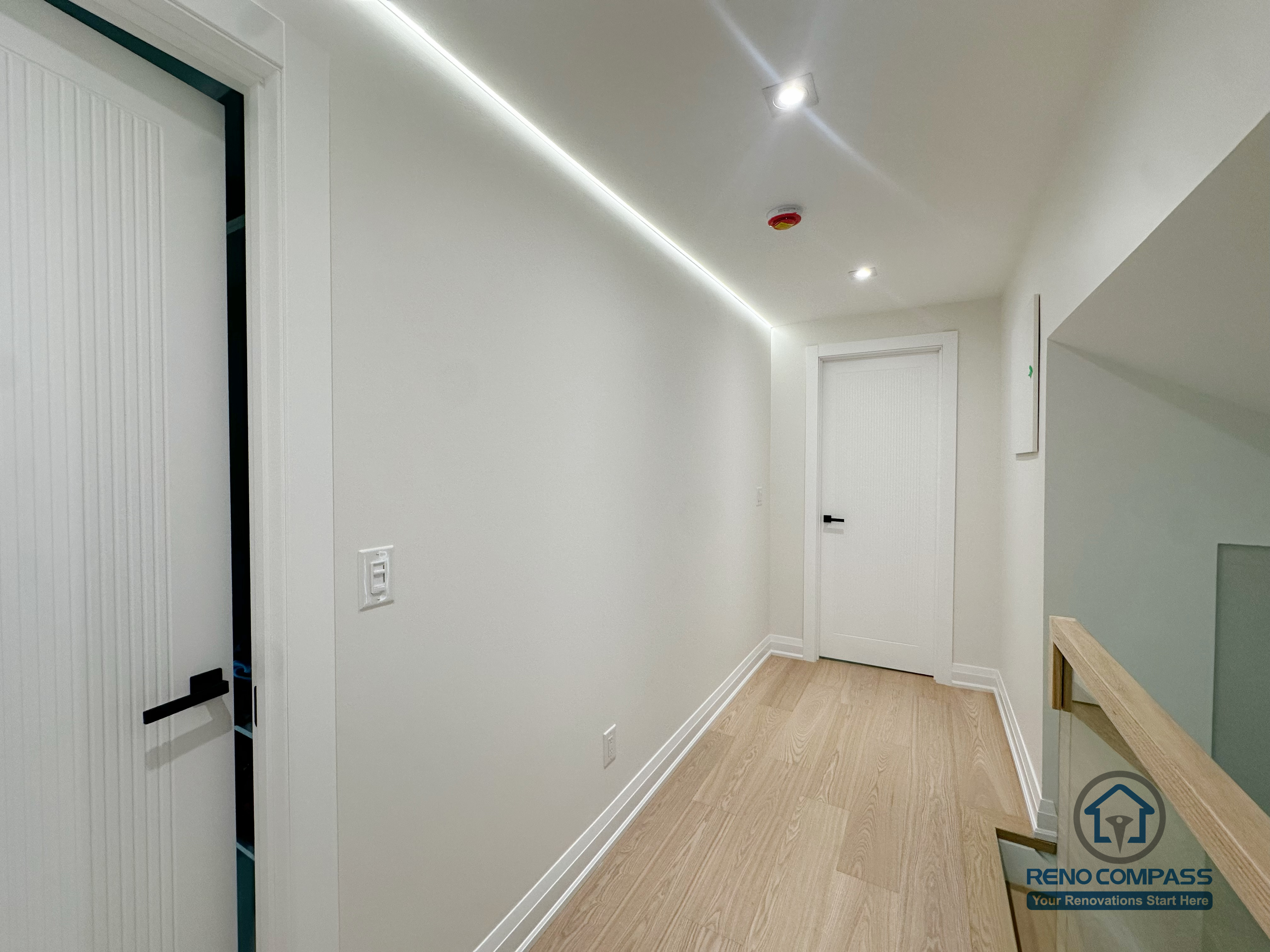 A clean and modern hallway design featuring soft LED cove lighting that visually expands the space. Light oak flooring and crisp white doors create a calm, airy transition area between rooms. A perfect example of how subtle lighting can elevate the entire home.
这条走廊以隐藏灯槽营造柔和光线，让空间更显明亮开阔。浅木色地板与纯白门片相互呼应，使过道成为家中舒适、干净的过渡区域。细节虽小，却明显提升整体质感。