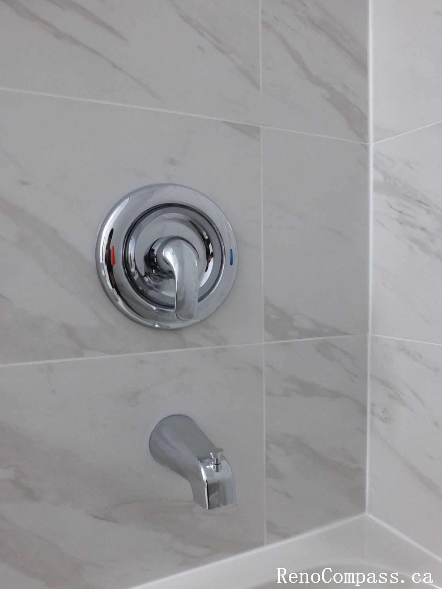 This Richmond Hill bathroom renovation detail highlights modern chrome shower fixtures paired with elegant marble-look wall tiles. Completed by a trusted Toronto renovation company, the installation focuses on precision, durability, and clean finishing. The sleek hardware and neutral tile design create a contemporary, low-maintenance bathing space with a refined and timeless appearance.
