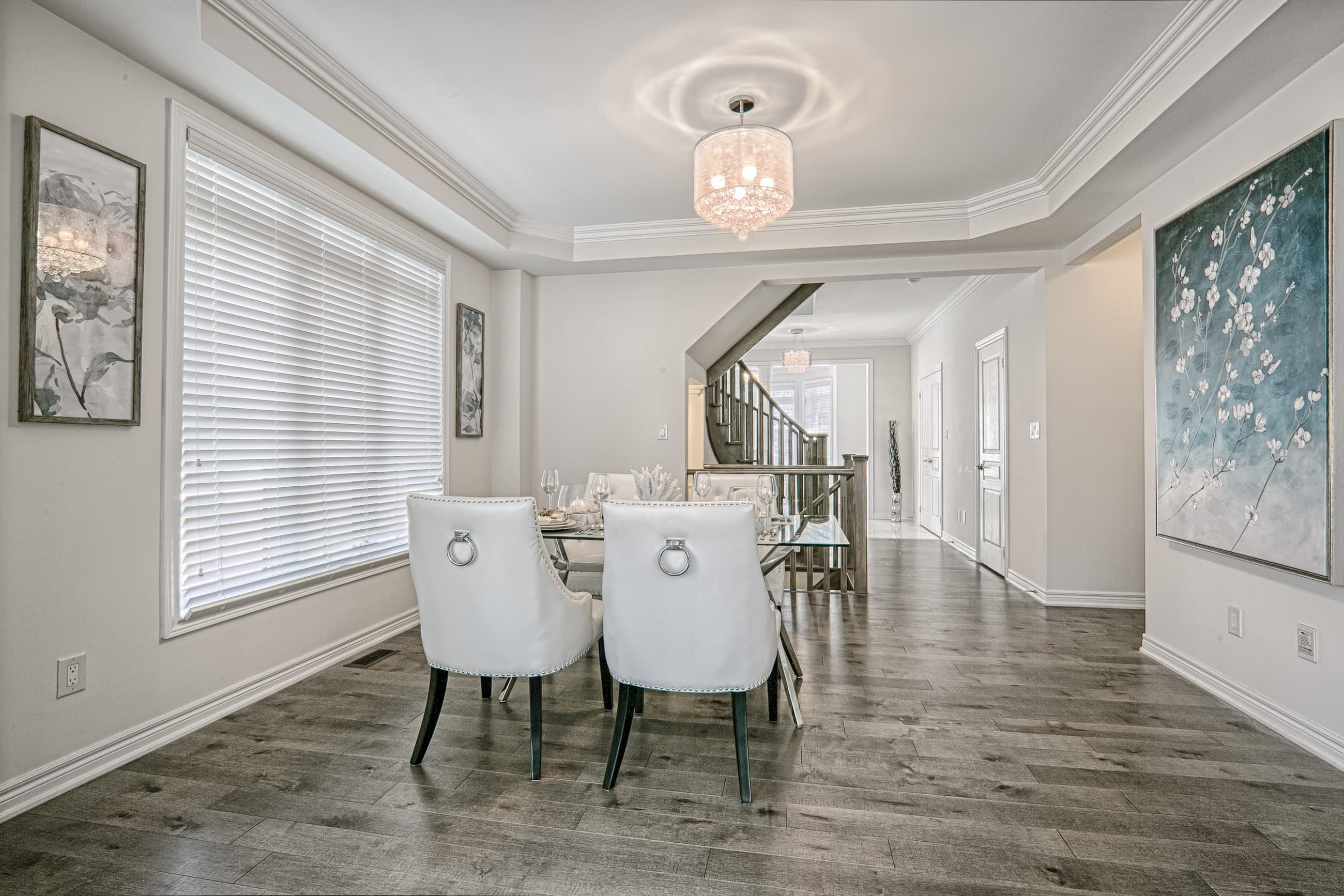 This Toronto luxury dining room renovation features an elegant open-concept layout with modern classic design elements, premium hardwood flooring, and refined lighting fixtures. The space is enhanced by large windows for natural light, custom ceiling details, and a seamless flow connecting the dining area to the hallway and staircase. Completed by a professional Toronto renovation company, this interior project highlights sophisticated finishes, spacious planning, and timeless residential design for modern family living.
