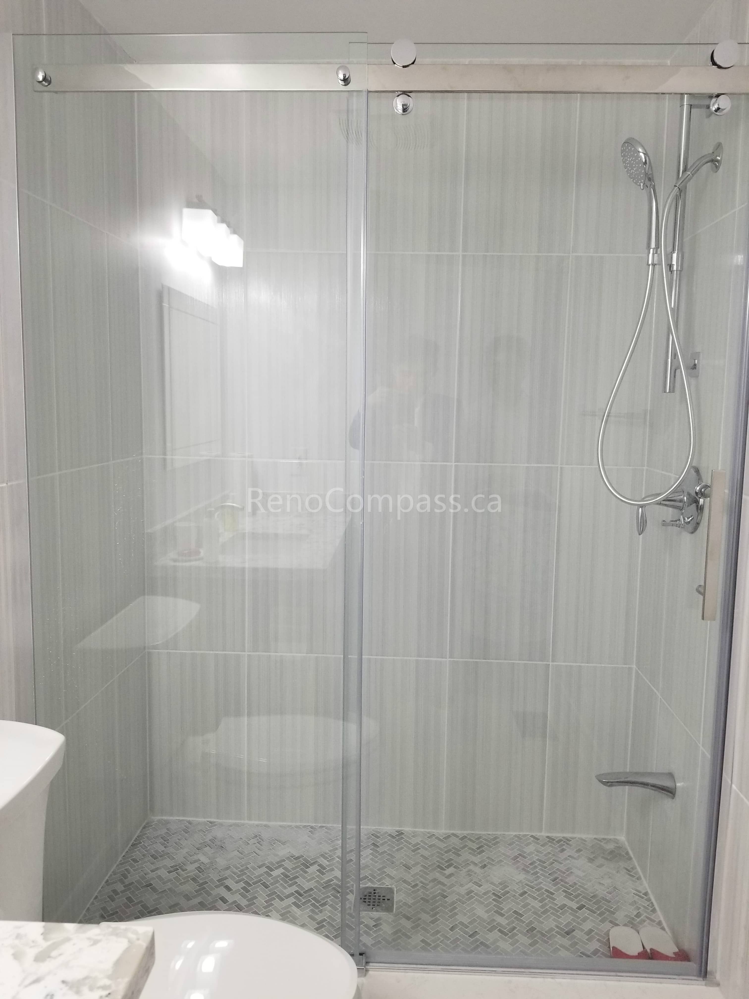 This Mississauga bathroom renovation features a sleek frameless glass shower enclosure with modern vertical wall tiles and mosaic shower flooring. The clean, minimalist design enhances brightness and creates a spacious, contemporary feel while improving everyday functionality and comfort.

Completed by Reno Compass Inc., this bathroom upgrade combines elegant finishes, quality materials, and professional installation to deliver a stylish and durable shower space for modern living.