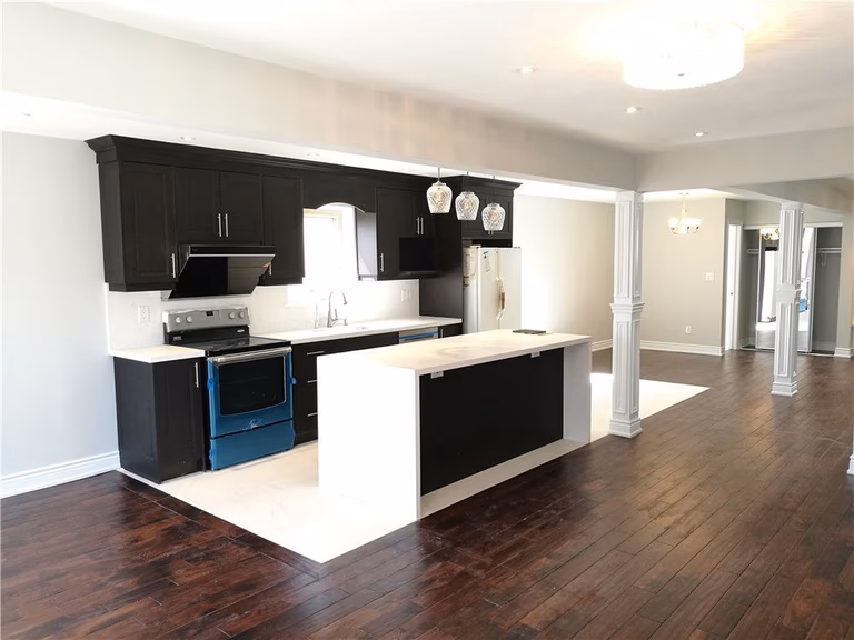 Complete whole-house interior renovation in Scarborough featuring a modern open-concept kitchen with custom dark cabinetry, quartz countertops, and a large center island. This renovation highlights new hardwood flooring, upgraded lighting, and a spacious layout designed for comfortable family living by a professional Toronto renovation contractor.