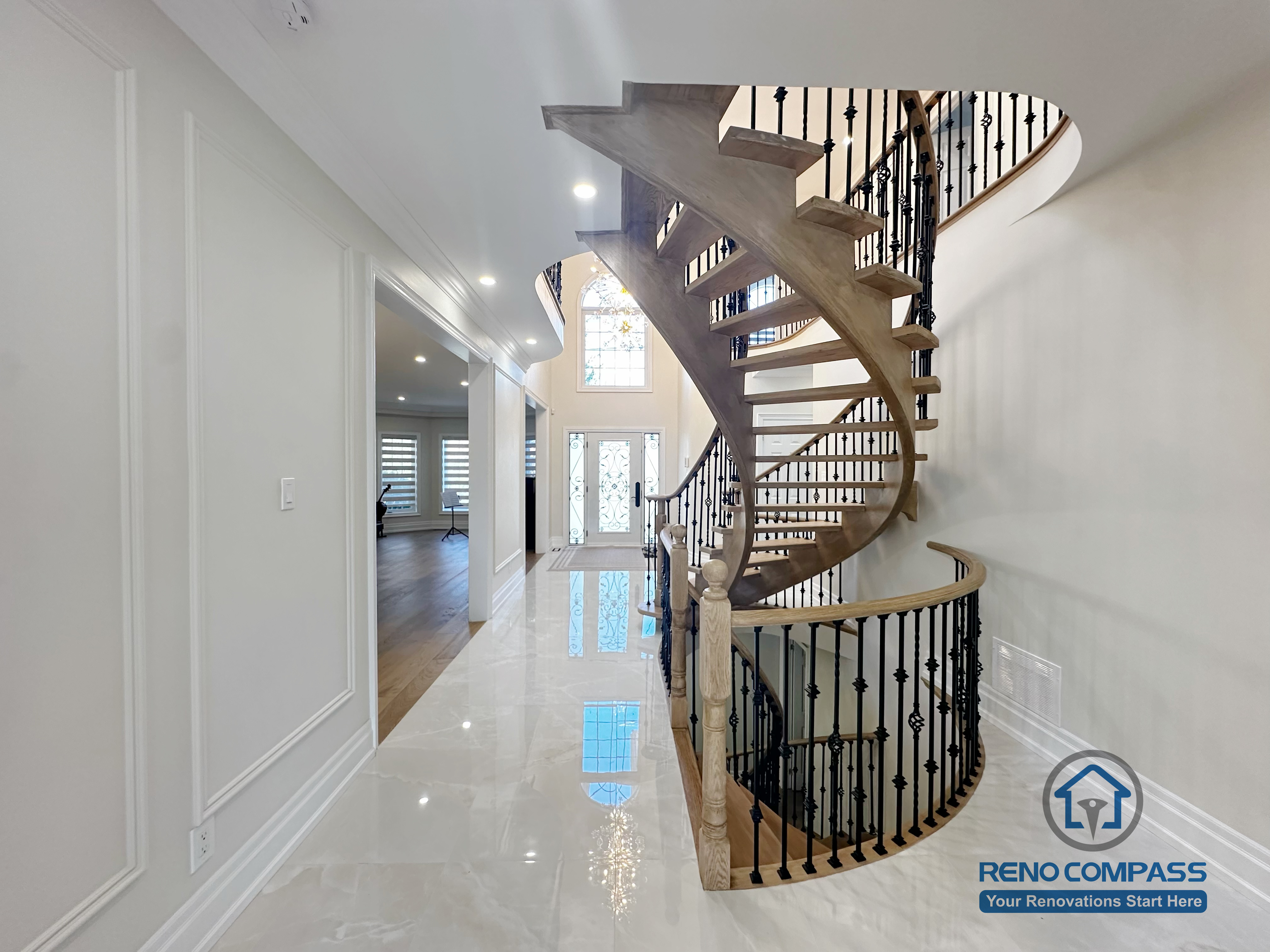 This image highlights a custom curved staircase featured in a North York flooring and stair renovation. The open-riser staircase is constructed with hardwood treads and paired with decorative iron railings, creating a visually light and sculptural form. The surrounding flooring and polished finishes enhance brightness and spatial flow throughout the main level. This design demonstrates precise craftsmanship and thoughtful integration of flooring and stair elements, contributing to a refined and cohesive interior layout for North York homes.
