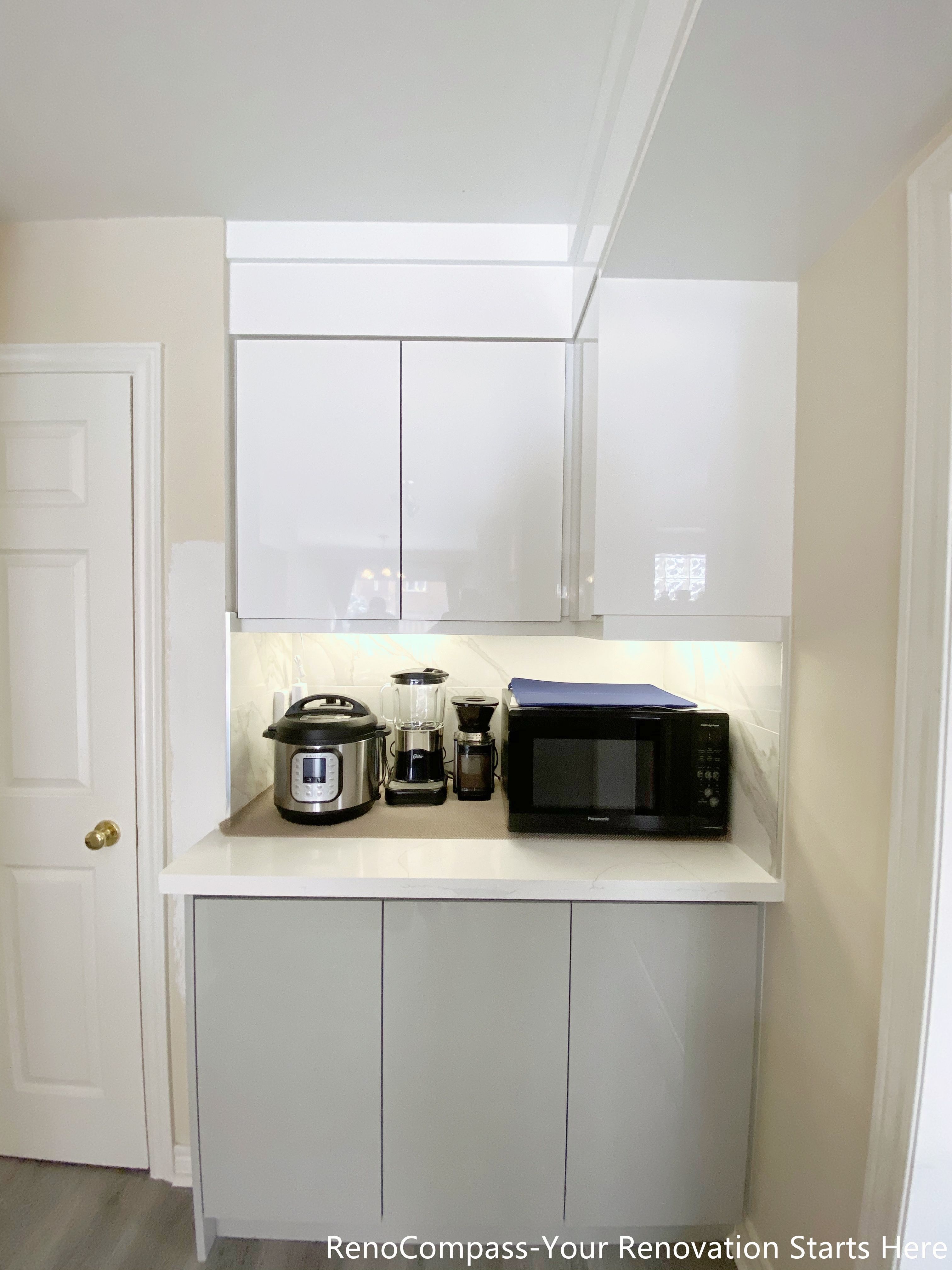 This image showcases a custom kitchen pantry cabinet completed as part of a Mississauga kitchen renovation. The design features full-height white cabinetry with integrated storage, a quartz countertop, and built-in appliances including a microwave, coffee machine, and rice cooker. Under-cabinet lighting enhances functionality and visibility, creating a clean and efficient prep zone. The layout maximizes vertical storage while maintaining a minimal, modern aesthetic, ideal for everyday use in contemporary Mississauga homes.