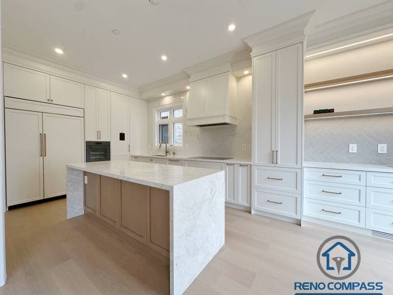 Modern Toronto kitchen with a large island, natural light from windows and patio doors, and an open layout that enhances functionality and spacious living.