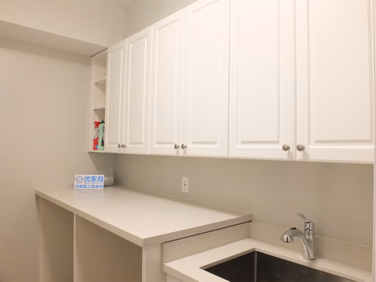 This Richmond Hill basement renovation features a functional utility area with custom cabinetry, a built-in sink, and extended countertop workspace. The clean design maximizes storage and practicality, making it ideal for laundry use, secondary kitchen prep, or additional household functionality.