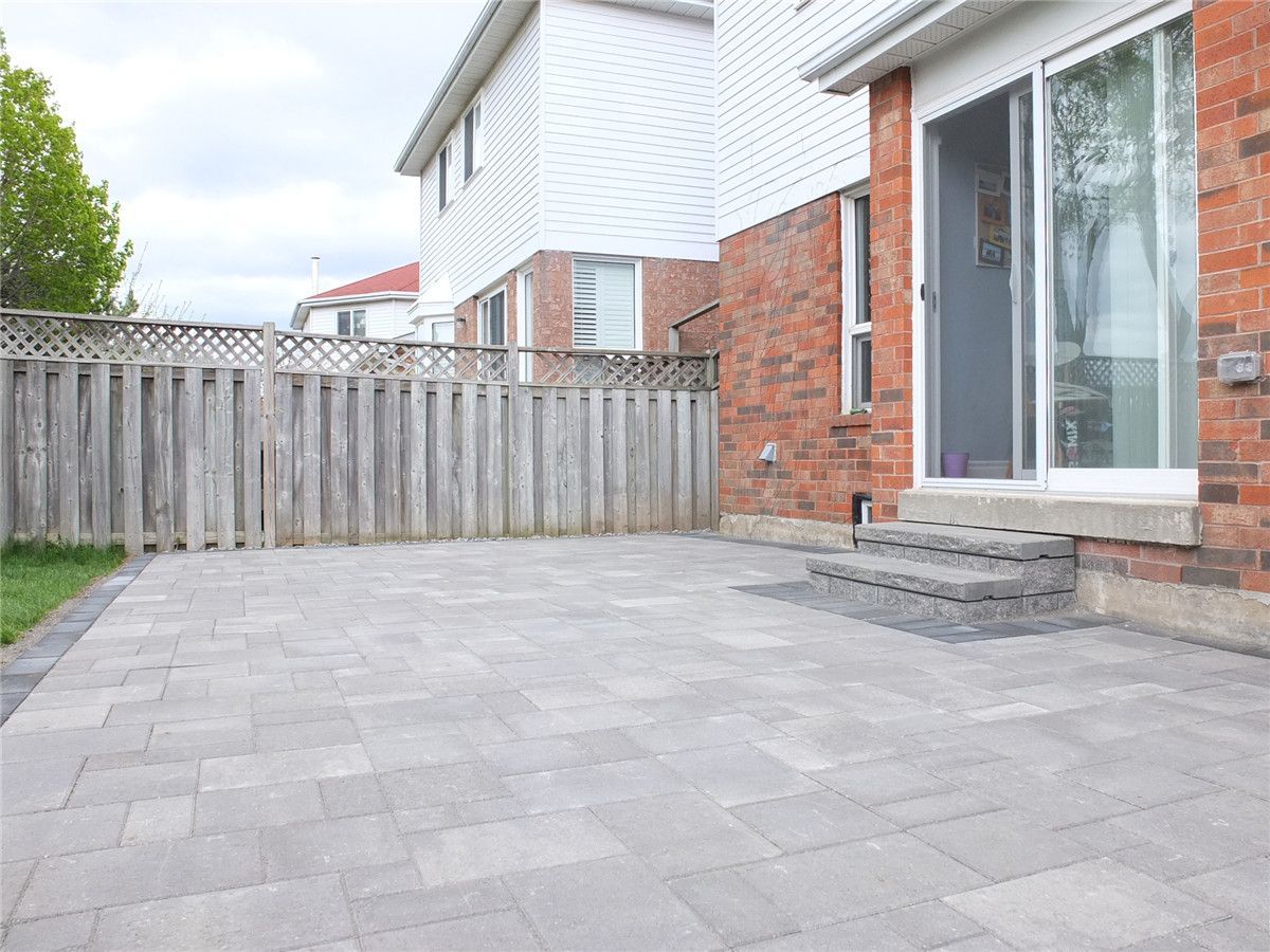 A newly completed backyard interlocking patio in Mississauga featuring large grey concrete pavers, clean step access to the back door, and a spacious low-maintenance outdoor living area. This landscaping and interlocking renovation enhances backyard usability and durability while creating a modern outdoor space. Completed by a trusted Toronto Renovation Company, Reno Compass Inc., serving Mississauga and the Greater Toronto Area.