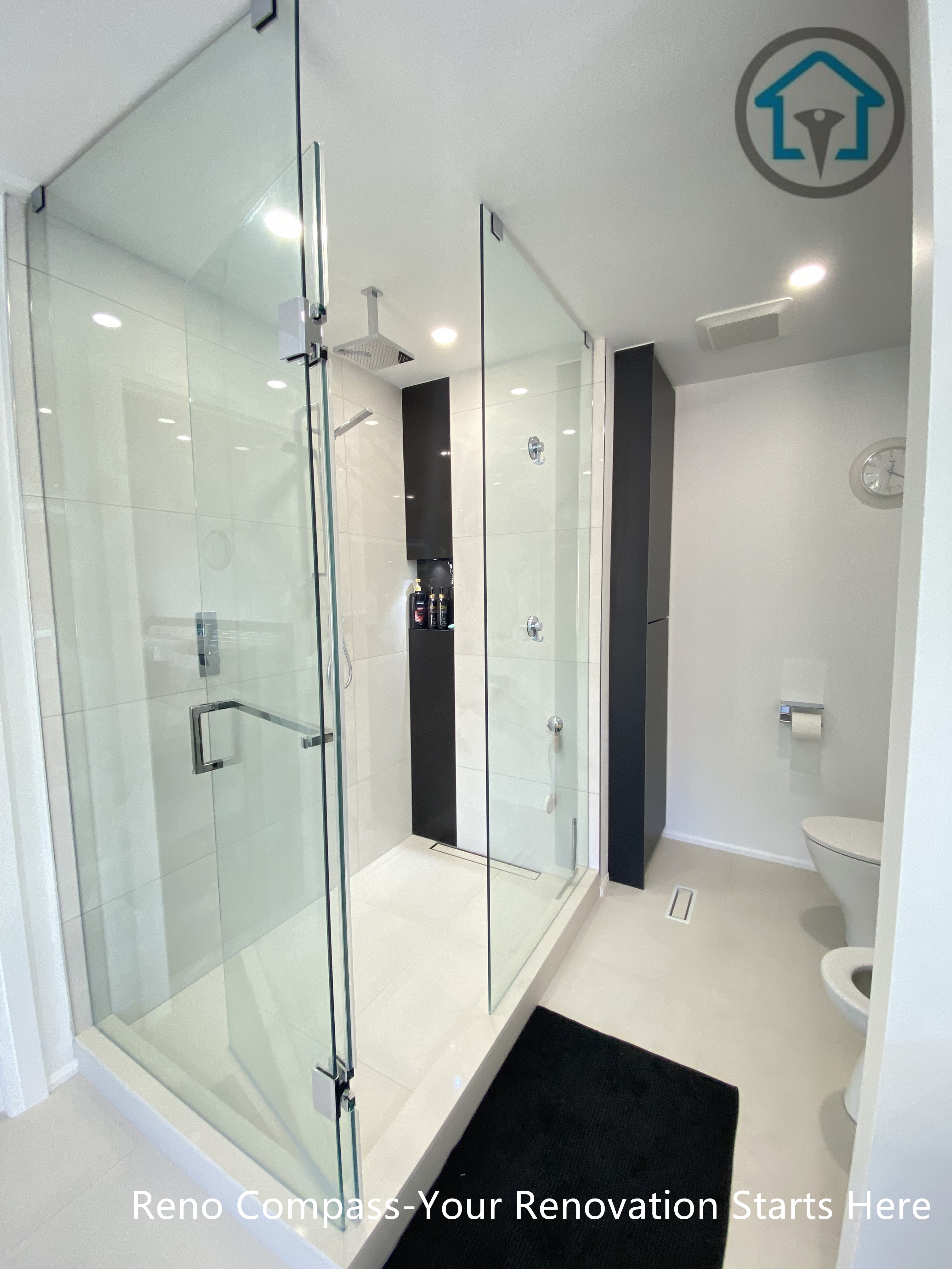 Modern bathroom renovation in Brampton featuring a frameless glass walk-in shower, large-format wall tiles, built-in shower niches, and a clean contemporary layout. The design emphasizes functionality, water protection, and visual openness, completed by a professional Toronto renovation company.
