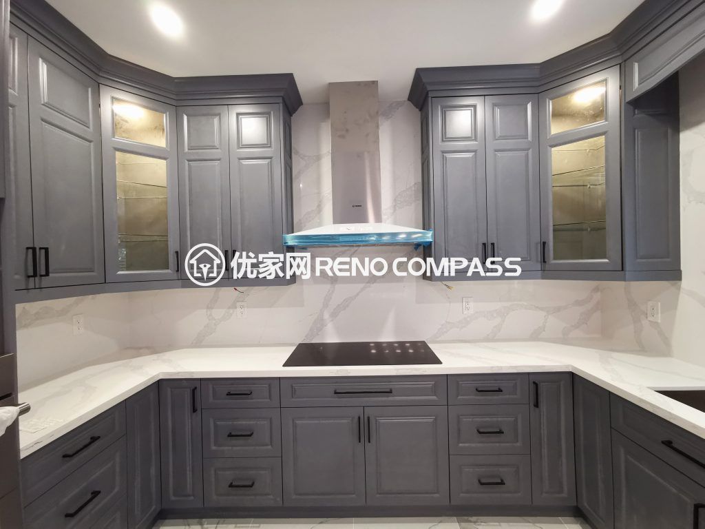 Richmond Hill kitchen renovation featuring custom grey shaker cabinets, quartz countertops, built-in cooktop, and modern range hood design. This interior renovation enhances storage, functionality, and contemporary style, completed by a professional Toronto renovation company.