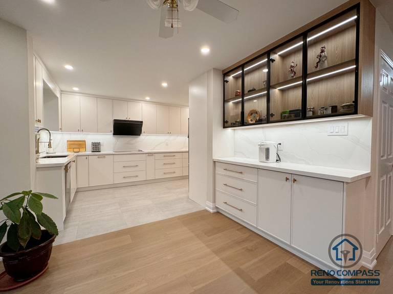 This Mississauga interior renovation features a modern kitchen upgrade paired with custom display cabinetry designed for both functionality and visual impact. The project combines clean white cabinetry, quartz countertops, and integrated lighting to create a bright and organized cooking space. A custom built-in display cabinet with accent lighting adds warmth and character, while maintaining a cohesive, open layout that connects seamlessly with the kitchen area. The overall design focuses on storage efficiency, refined details, and a balanced modern aesthetic suited for contemporary Mississauga homes.