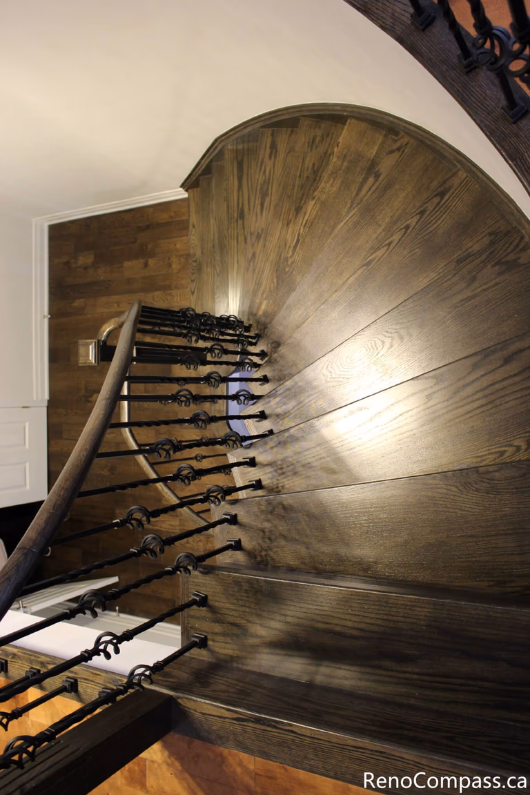 This Mississauga interior renovation features a beautifully crafted curved hardwood staircase with custom iron balusters and rich wood detailing. The spiral design enhances architectural flow while adding a dramatic and elegant focal point to the home. Completed by a professional Toronto renovation company, Reno Compass Inc., this project highlights precision carpentry, premium materials, and refined interior craftsmanship.