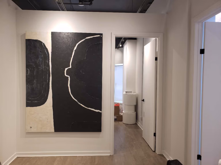 This image showcases a modern hallway and feature art wall within a beauty and massage spa, completed by a professional Toronto renovation company specializing in commercial interior renovations. The space highlights clean wall finishes, contemporary artwork installation, and strategic lighting that enhances visual depth and brand identity. Durable wood-look flooring and a streamlined corridor layout ensure smooth client flow between treatment rooms while maintaining a calm and upscale spa atmosphere. This design approach is ideal for wellness clinics, beauty studios, and medical spa interiors across Toronto and the GTA seeking a modern, welcoming, and professionally renovated environment.