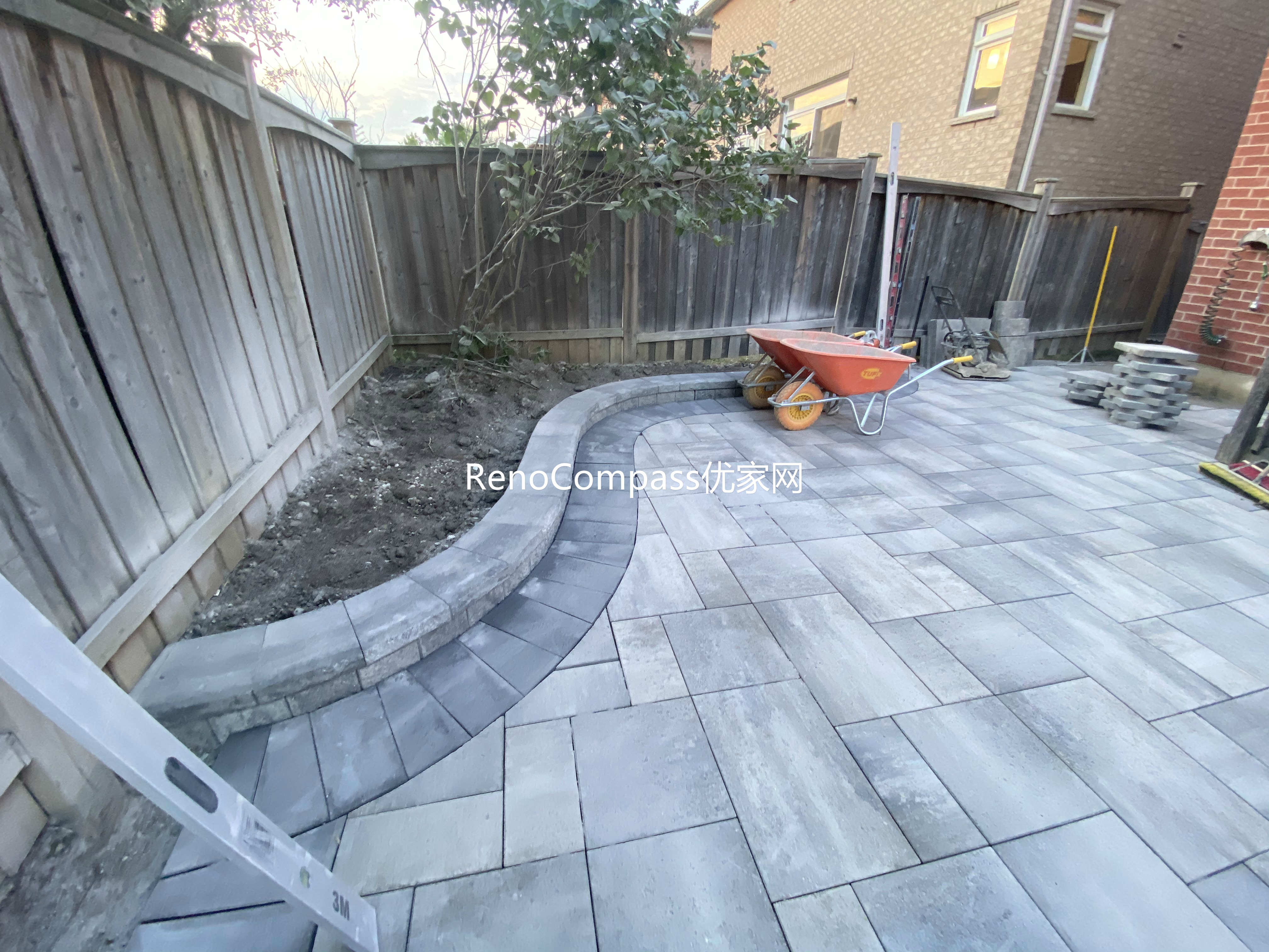 This Markham landscaping and interlocking project features a custom stone patio designed with a curved edge layout to soften the backyard space and improve flow. Large-format interlocking pavers were installed with precise alignment, creating a durable and visually balanced outdoor surface suitable for seating and everyday use. Integrated pathway lighting enhances safety and nighttime visibility, while the patio connects seamlessly with the existing wooden deck and side walkway. The combination of clean stone patterns and thoughtful layout delivers a functional, low-maintenance backyard upgrade completed by Reno Compass, serving homeowners in Markham and the surrounding GTA.