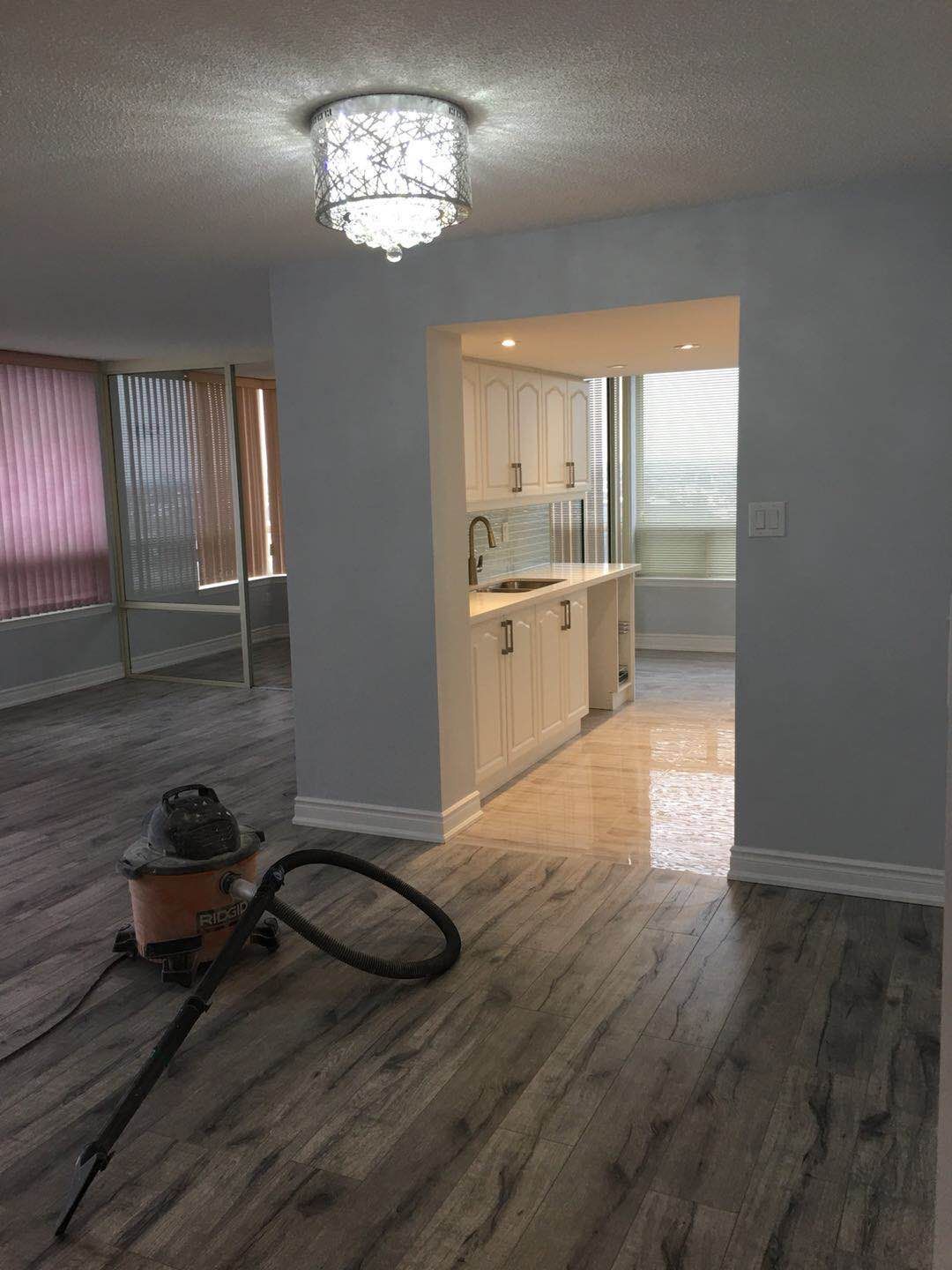 This Toronto interior renovation project showcases a refreshed hallway space featuring durable wood-look flooring, newly painted walls, updated trim, and modern ceiling lighting. The renovation improves brightness and flow between rooms while creating a clean and cohesive look for the home's interior layout.