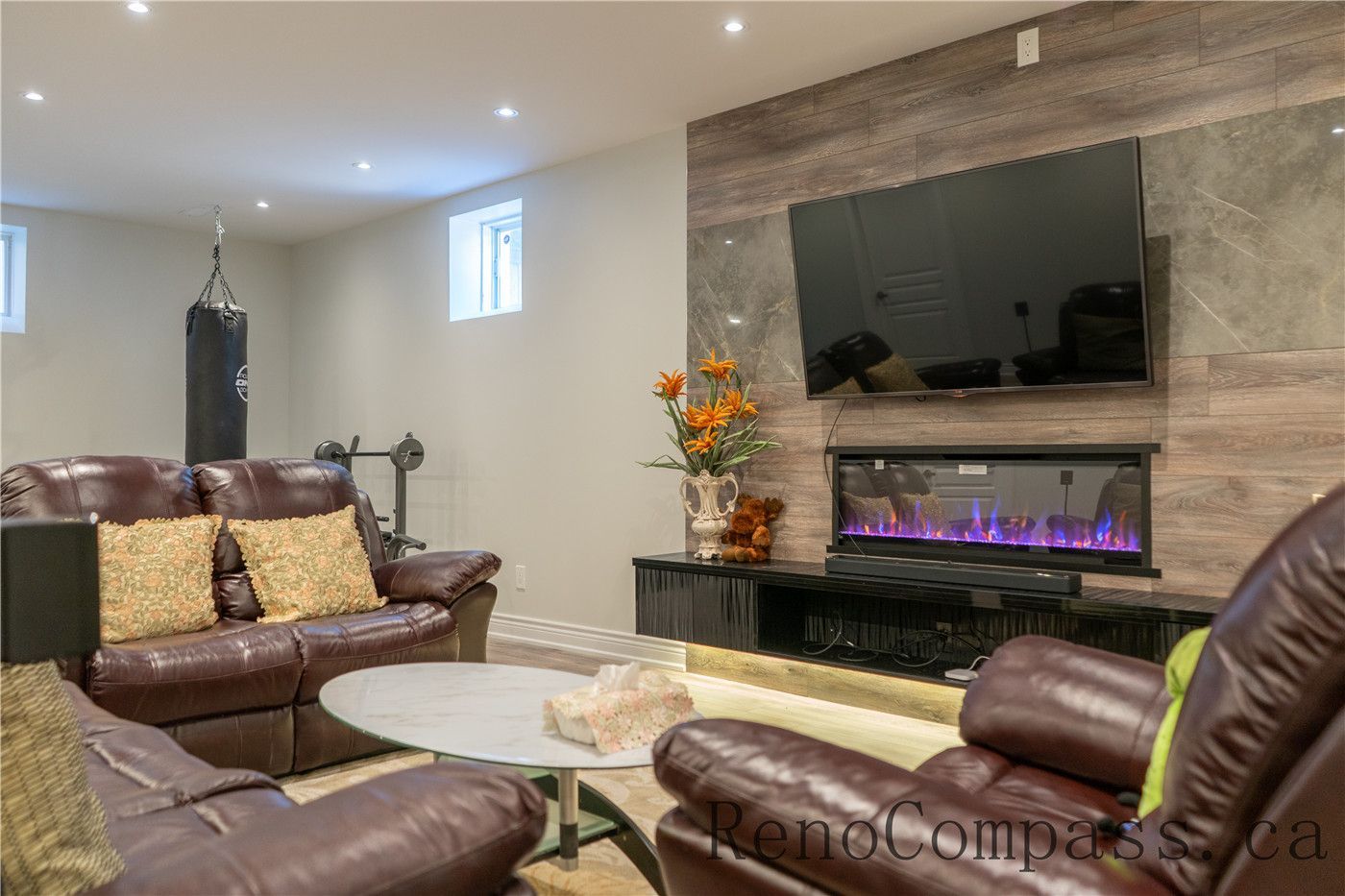 This Richmond Hill basement renovation features a modern living room with custom TV feature wall, built-in electric fireplace, upgraded flooring, and recessed lighting. Designed for comfort and entertainment, the warm and functional layout highlights the craftsmanship of a trusted Toronto renovation company specializing in full house and basement renovations.